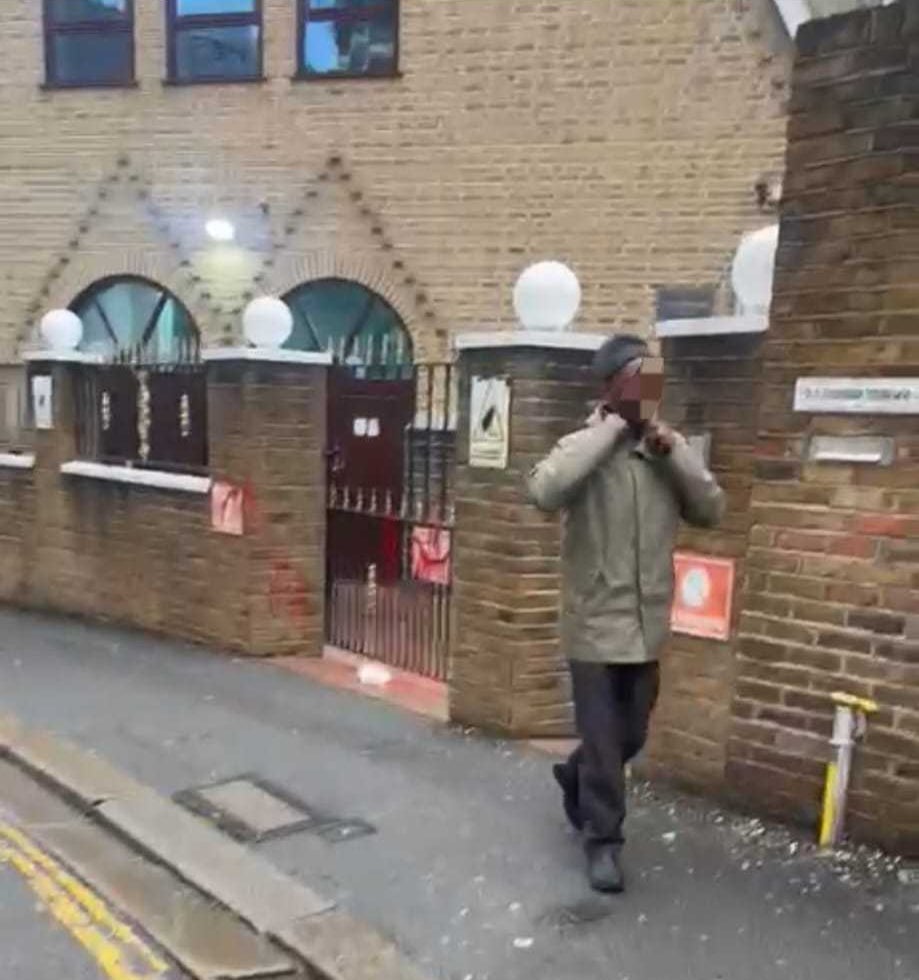 A worshipper walks away from the vandalised Acton Central Mosque