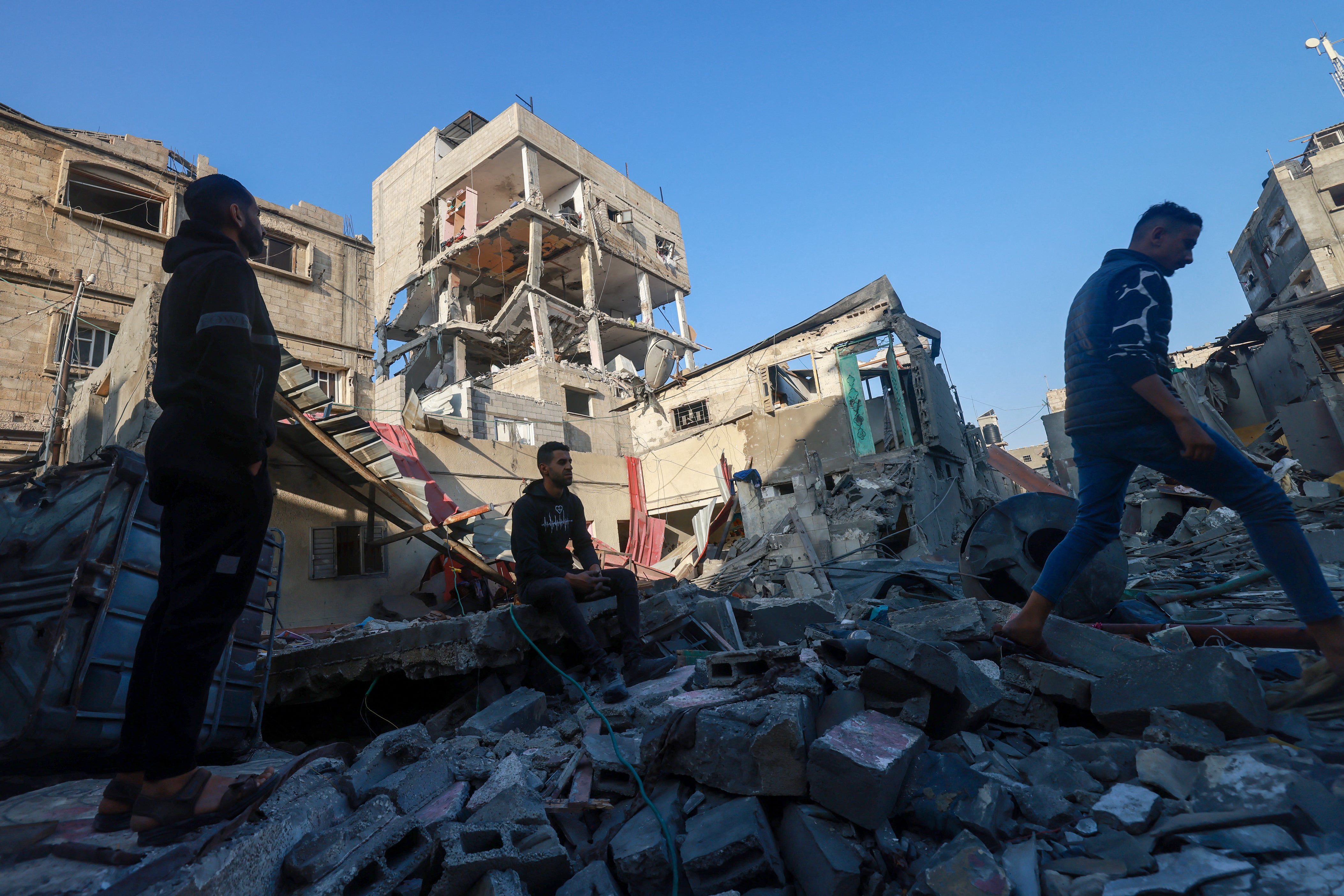 Palestinians inspect a building damaged during Israeli bombardment in Rafah in the southern Gaza Strip