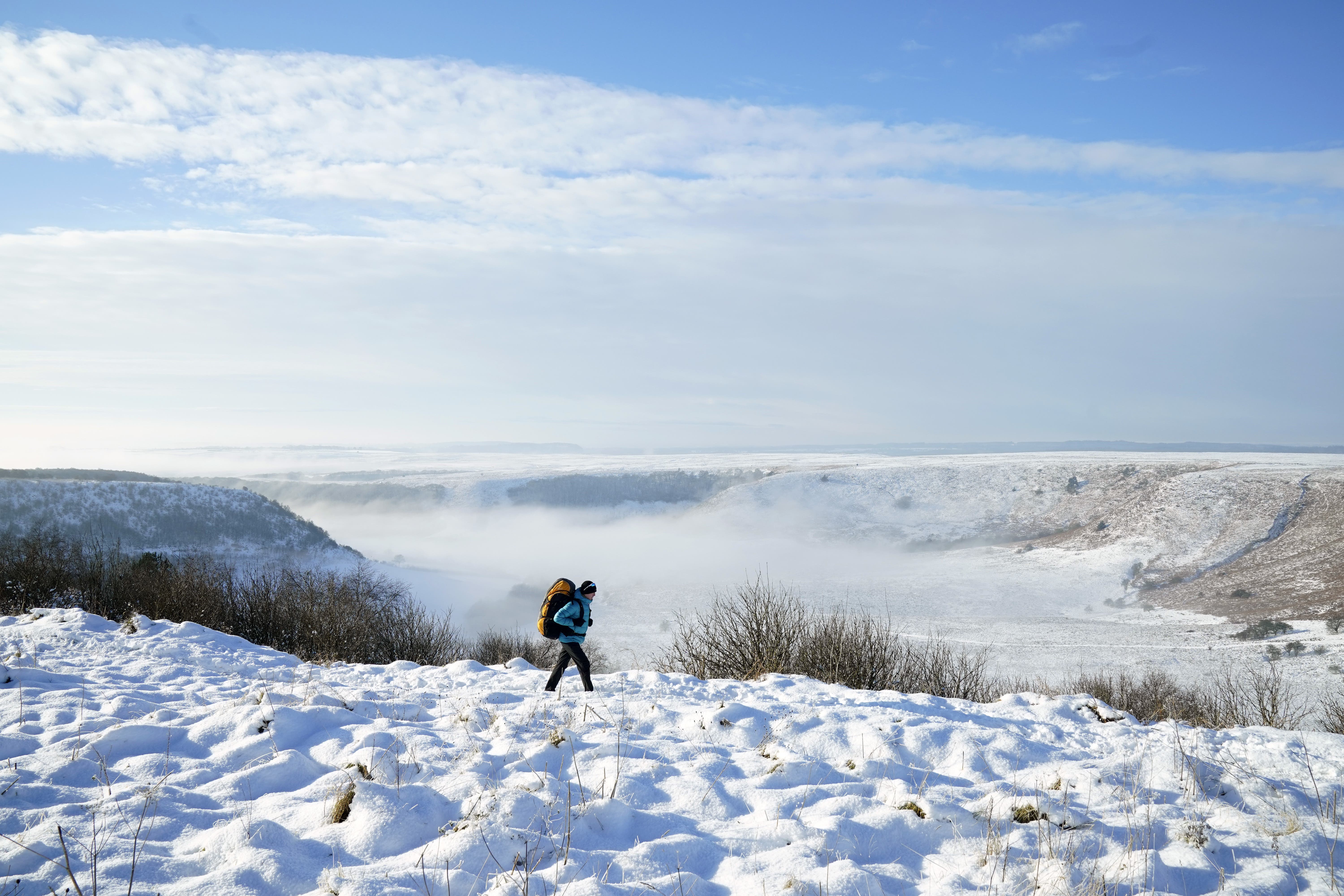 A person walks through snow above the Hole of Horcum at the North York Moors National Park (Danny Lawson/PA)