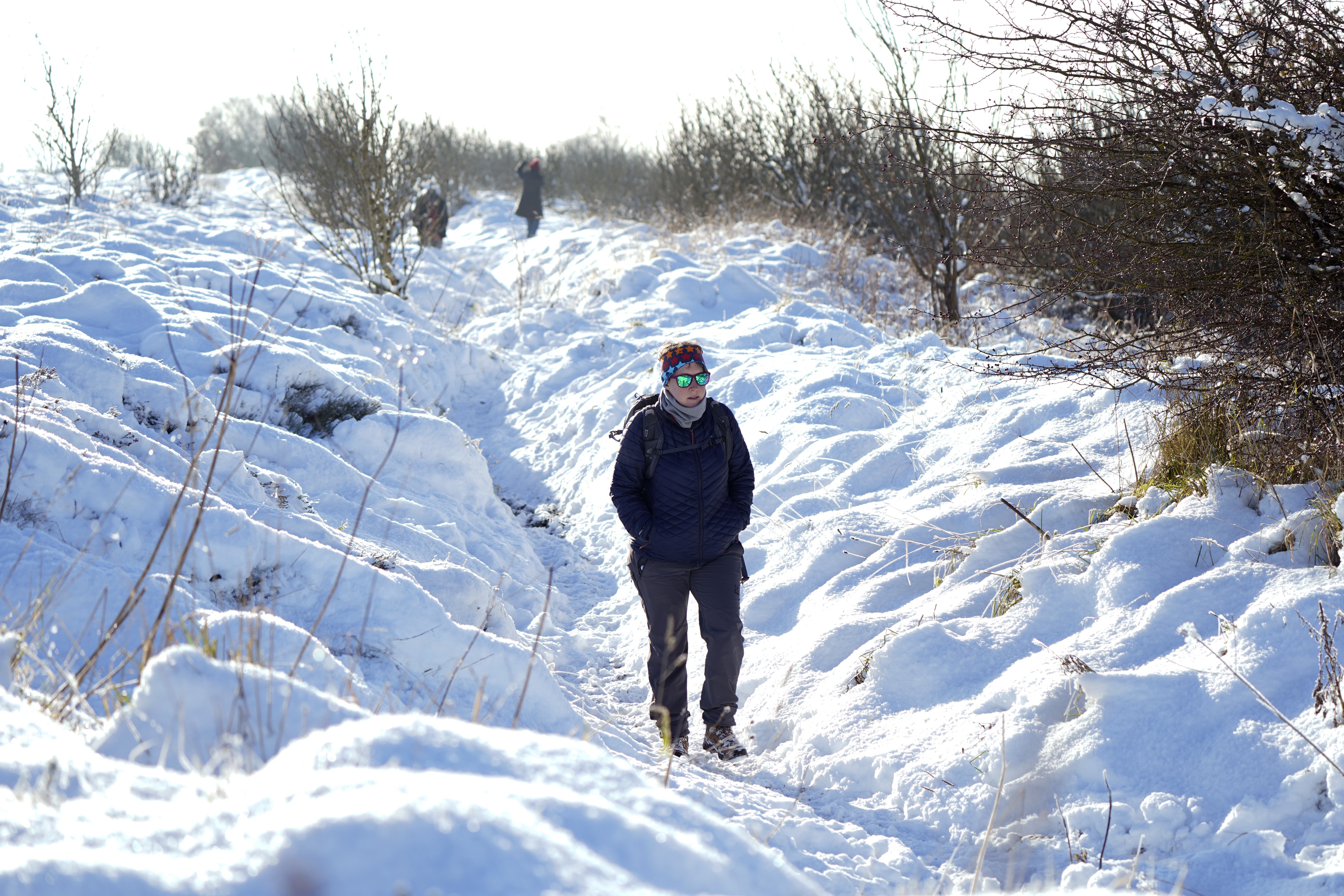 A person walks through snow above the Hole of Horcum at the North York Moors National Park (Danny Lawson/PA)