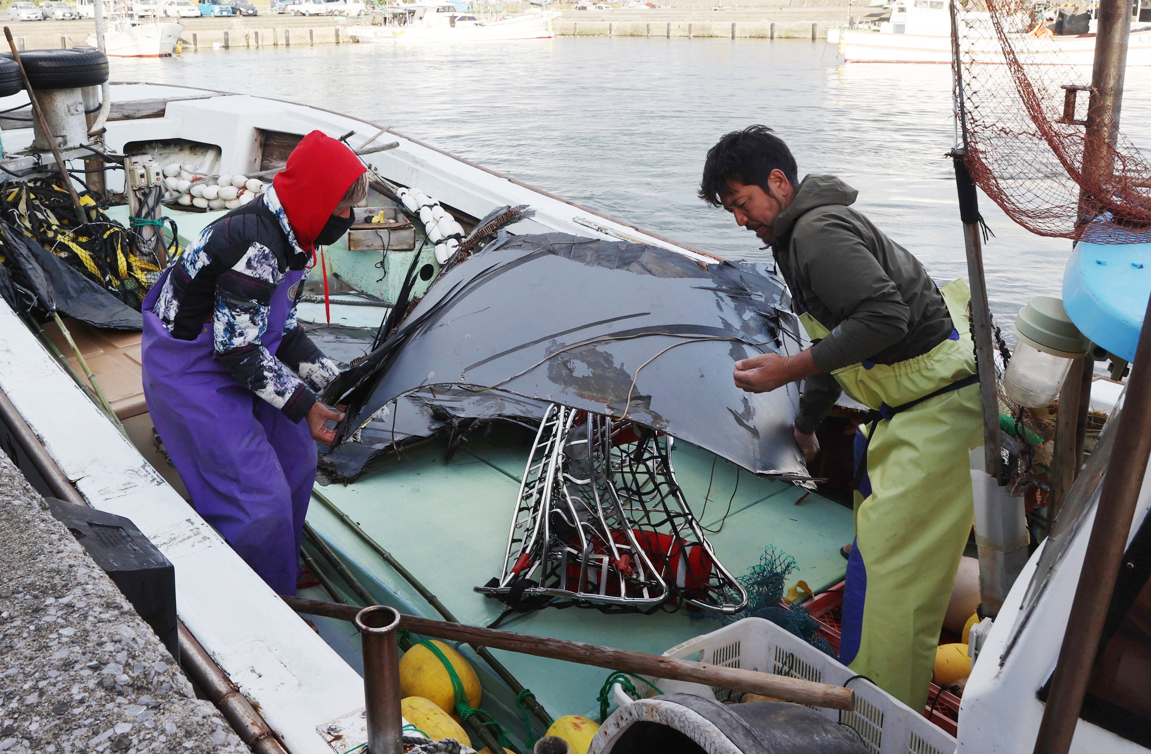 Fishermen participating in a searching operation unload recovered parts believed to be pieces of wreckage from the fuselage of a U.S. Air Force CV-22 ‘Osprey’ transport aircraft are from their boat at a port on Yakushima Island, Kagoshima Prefecture, Japan, 30 November 2023