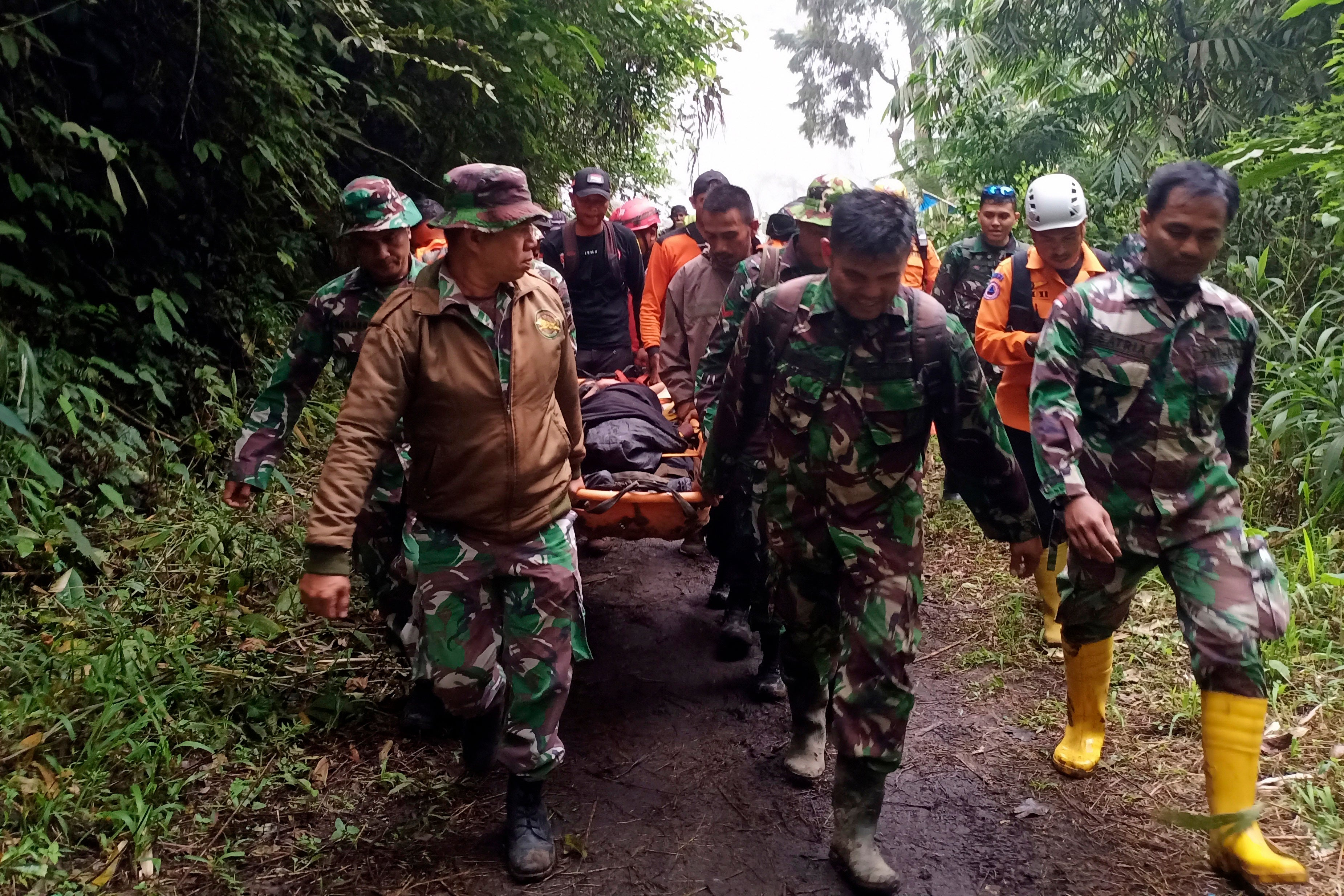 Rescuers carry a climber injured in the eruption of Mount Marapi in Agam, West Sumatra