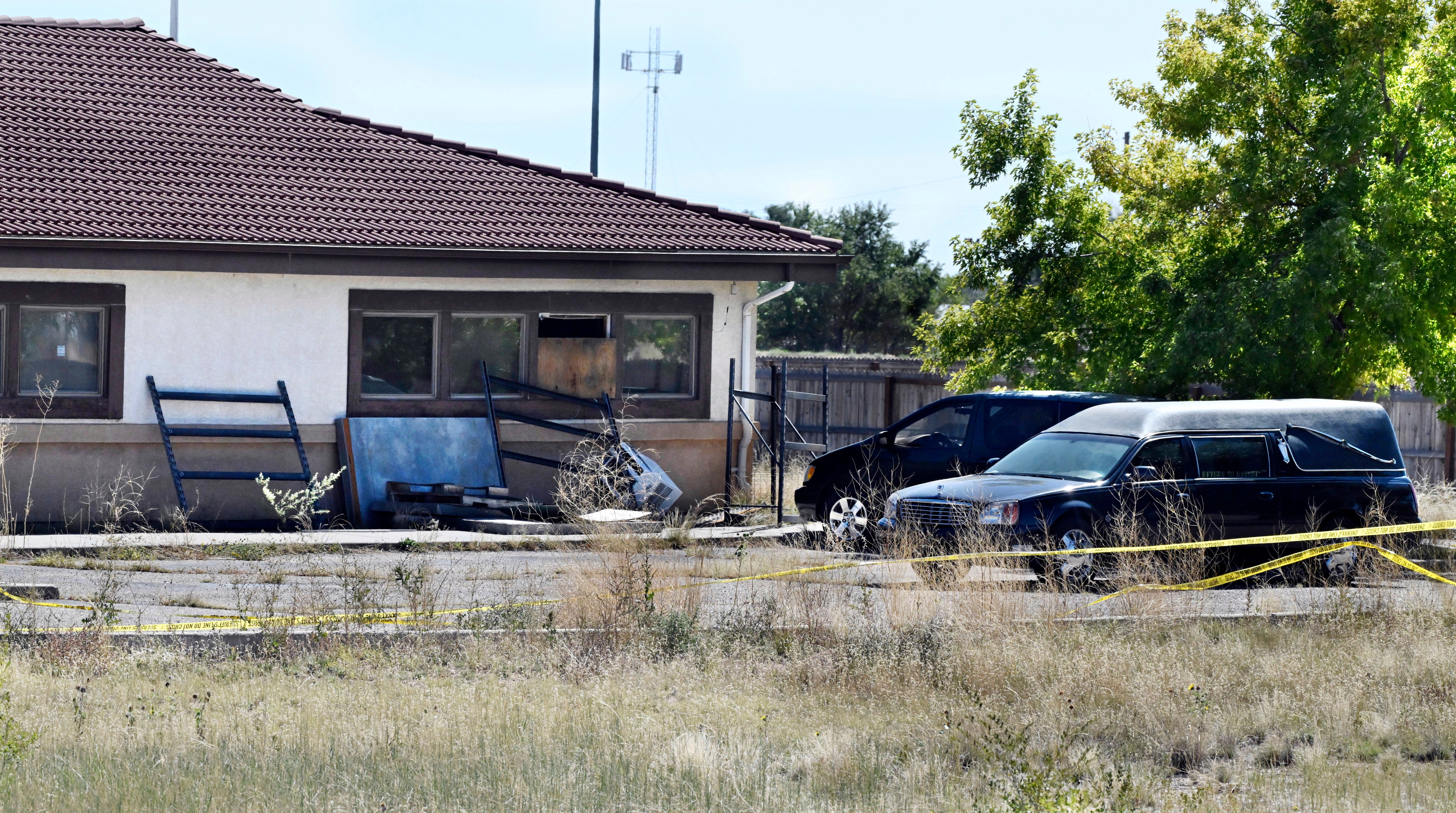 A hearse and debris can be seen at the rear of the Return to Nature Funeral Home, Oct. 5, 2023, in Penrose, Colo