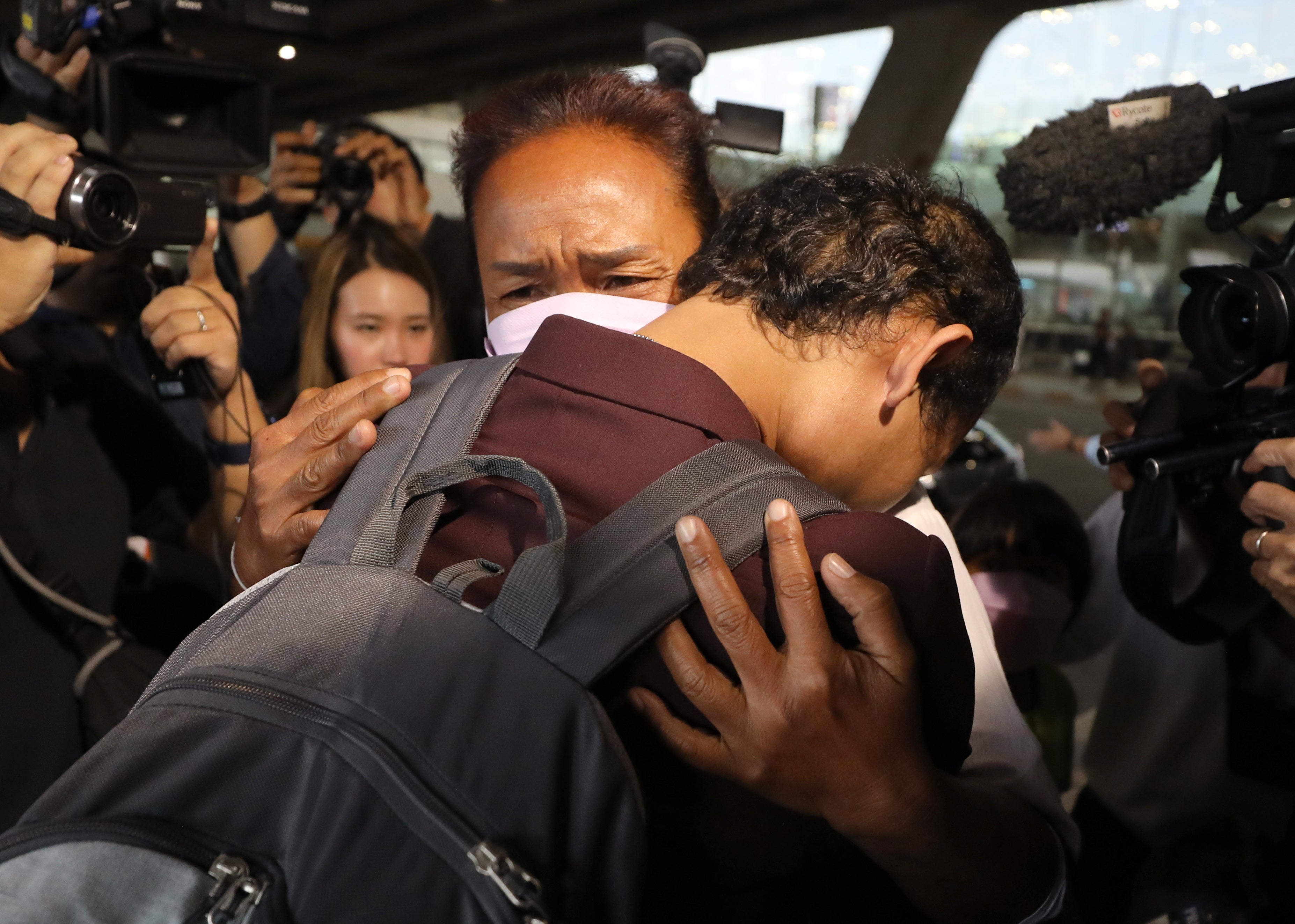 Thai migrant worker Phonsawan Pinakalo (L), who was taken hostage by the Palestinian militan group Hamas in the 07 October attacks on Israel, hugs his mother