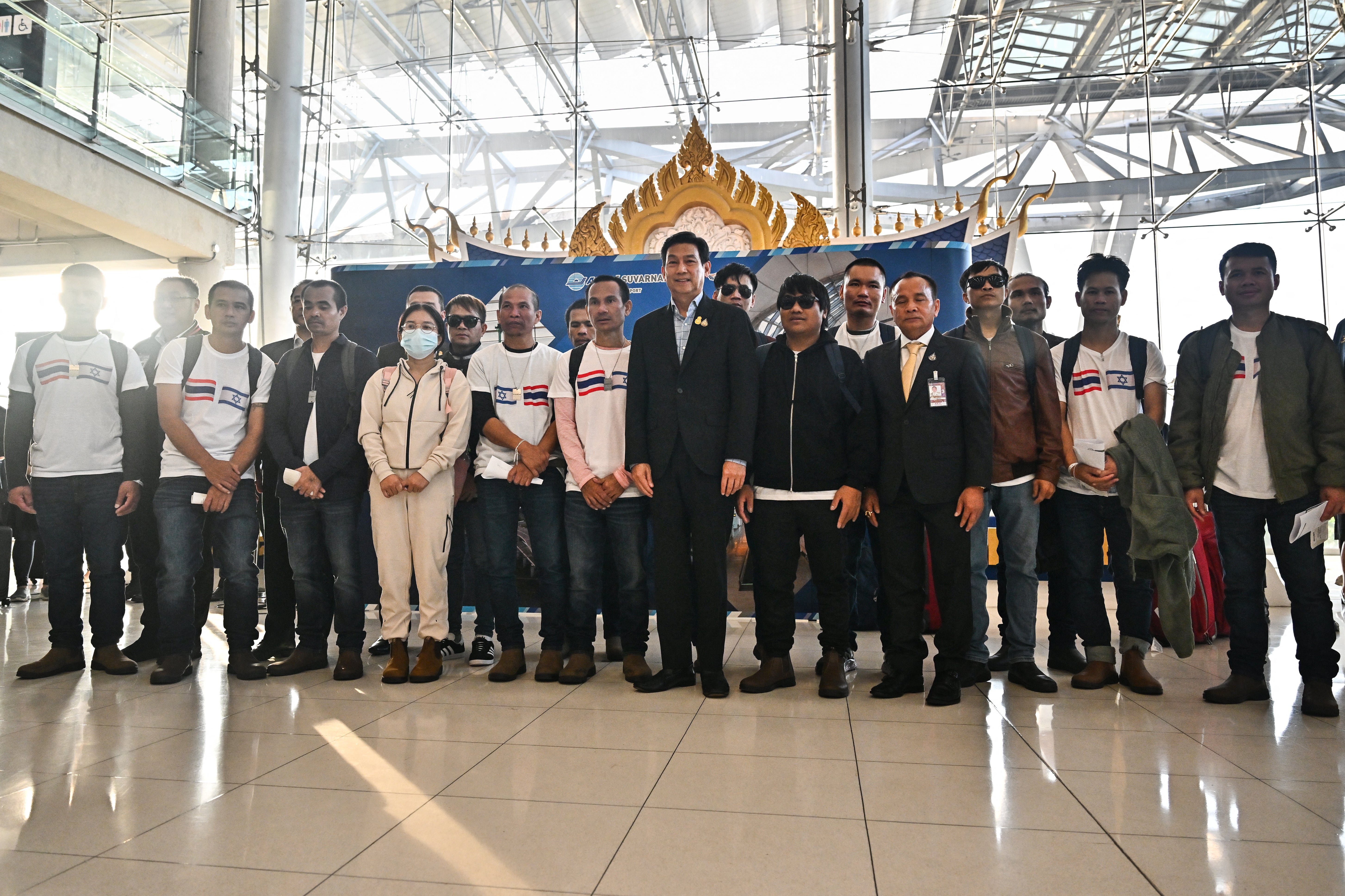 Thailand’s foreign minister Parnpree Bahiddha-Nukara (C) poses with Thai nationals, who had been kidnapped and taken hostage by Palestinian Hamas militants