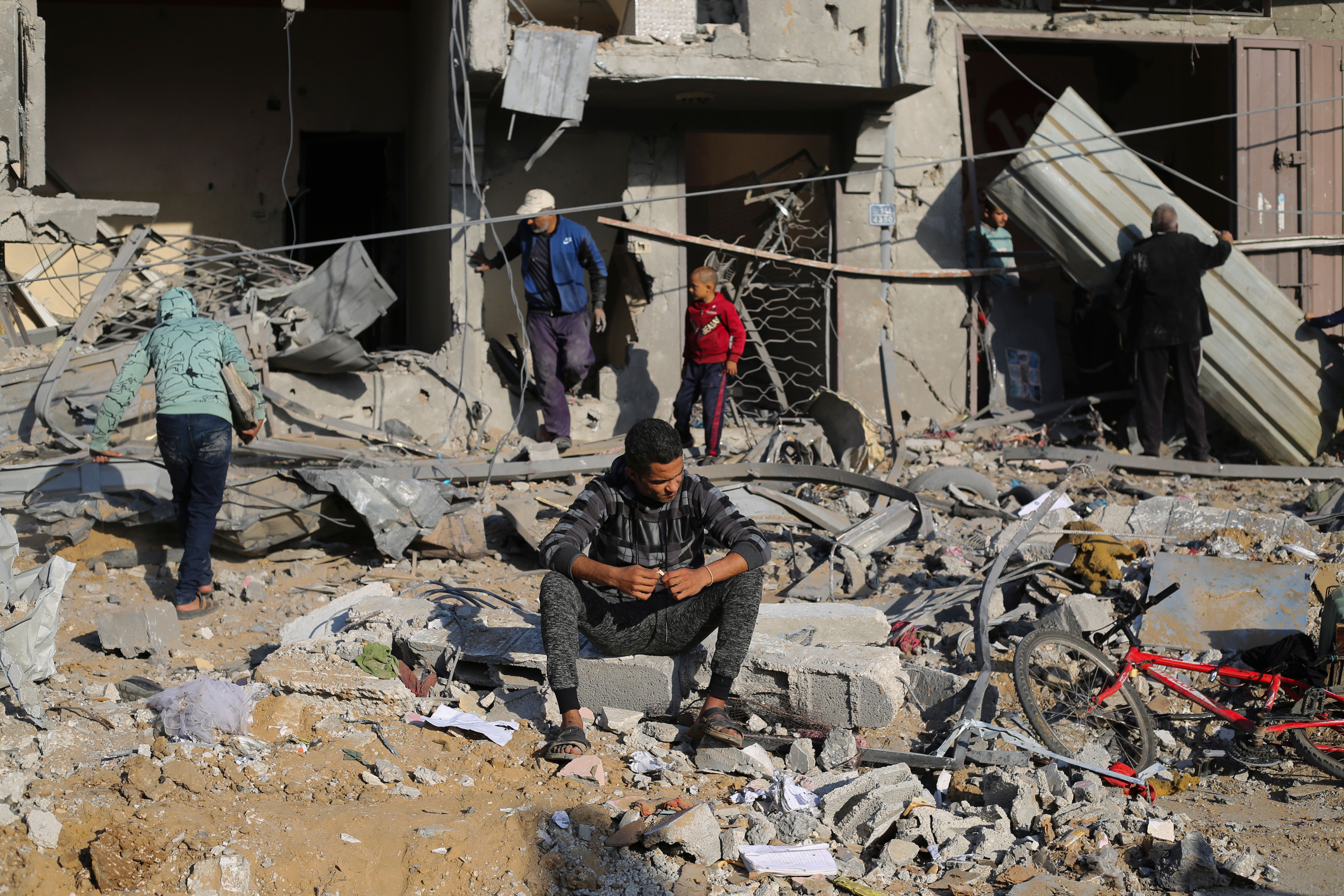 Palestinians look at the destruction by the Israeli bombardment of the Gaza Strip in Rafah (Hatem Ali/AP)