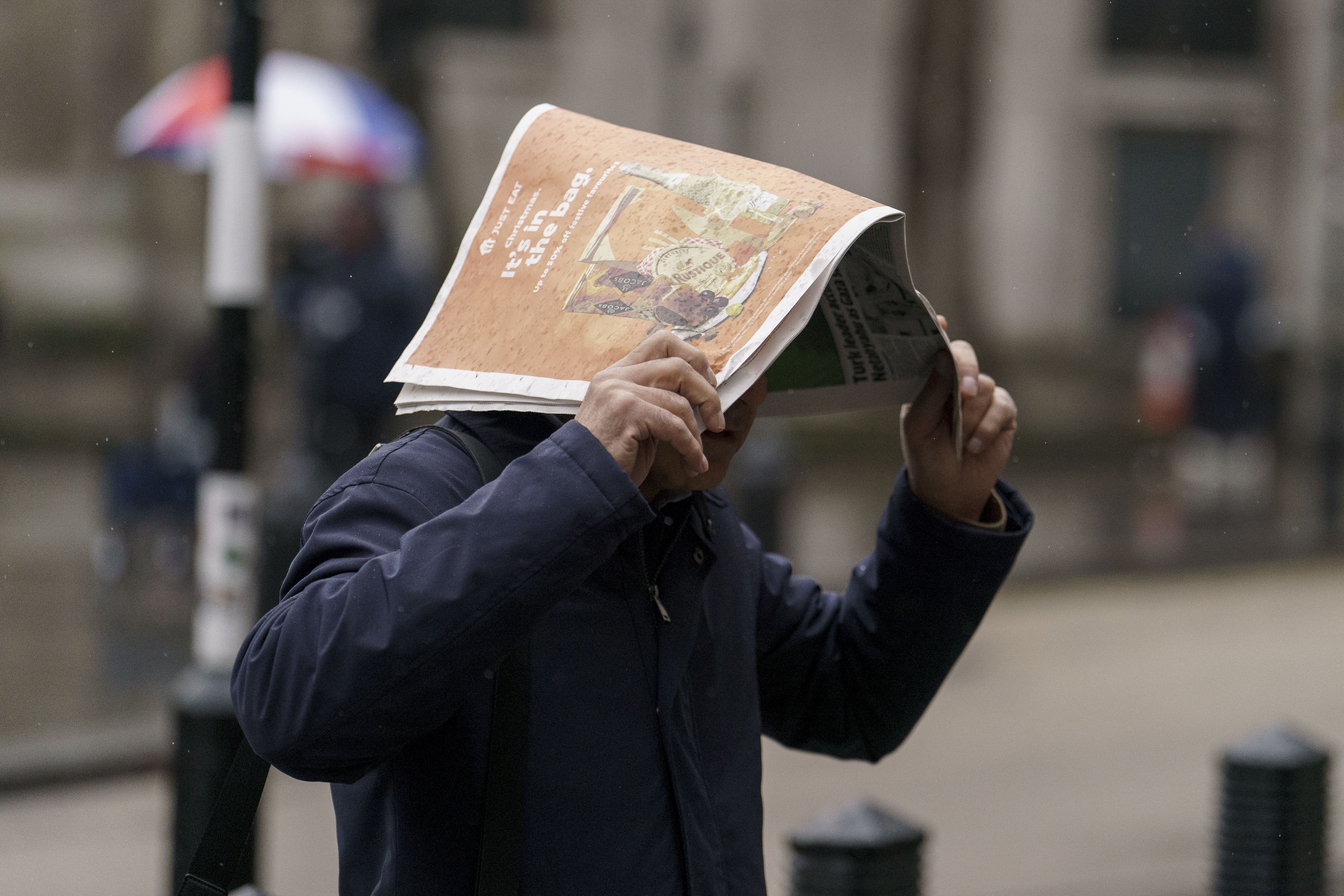 Members of the public shelter from the rain along the Strand in London on December 5 (Jordan Pettitt/PA)