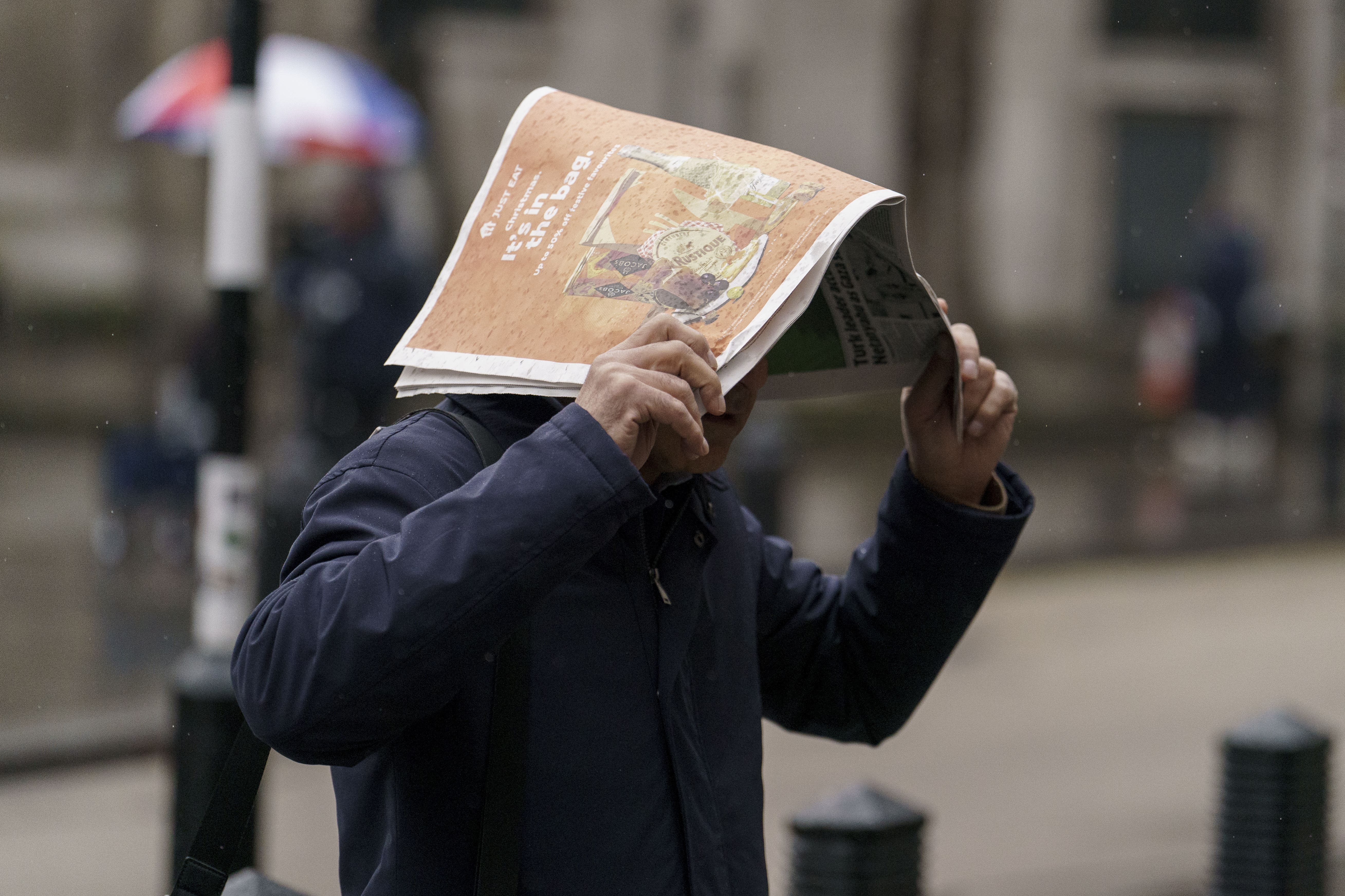 Members of the public shelter from the rain along the Strand in London (Jordan Pettitt/PA)