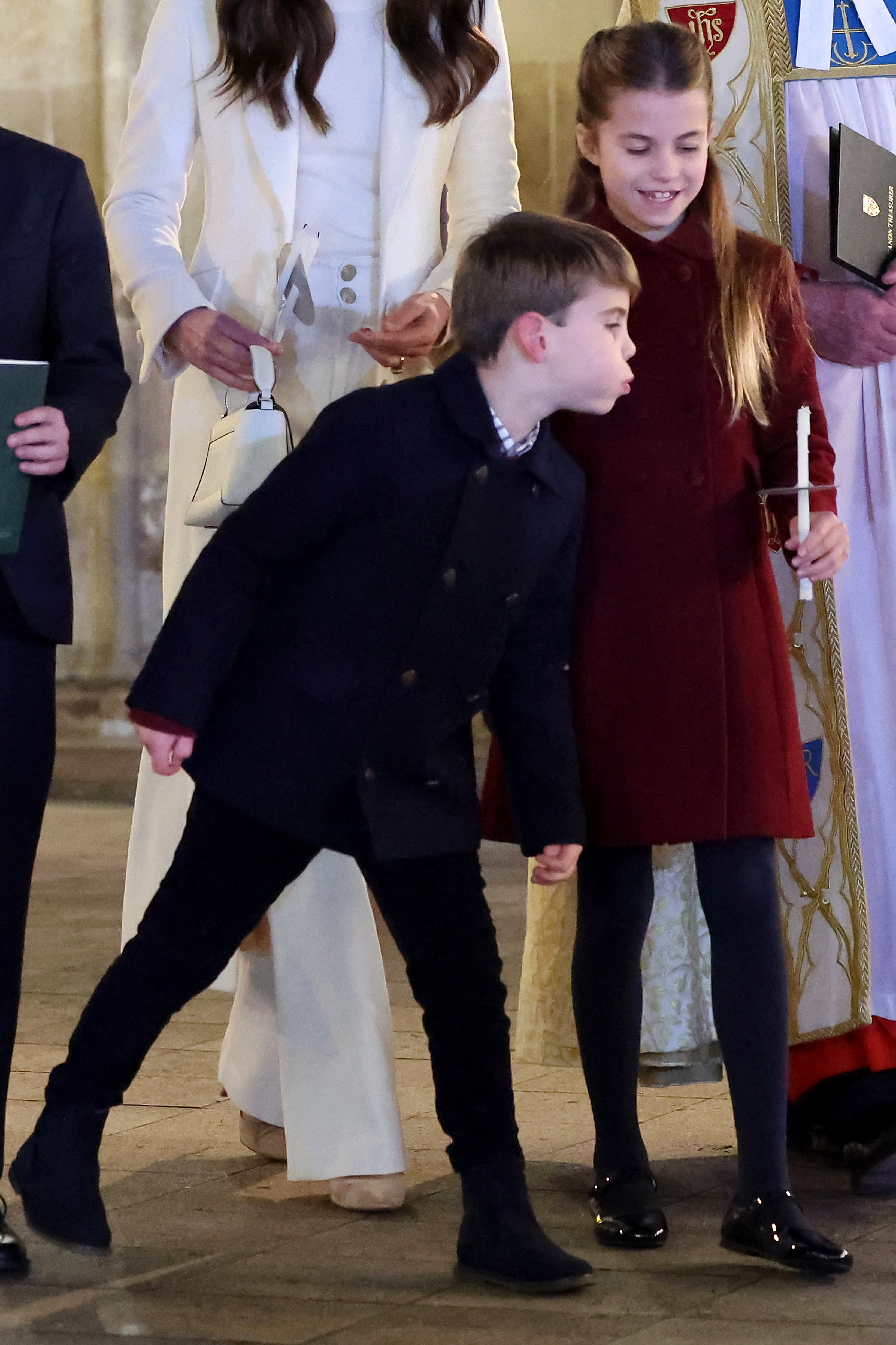 Prince Louis attempts to blow out of the candle his sister is holding