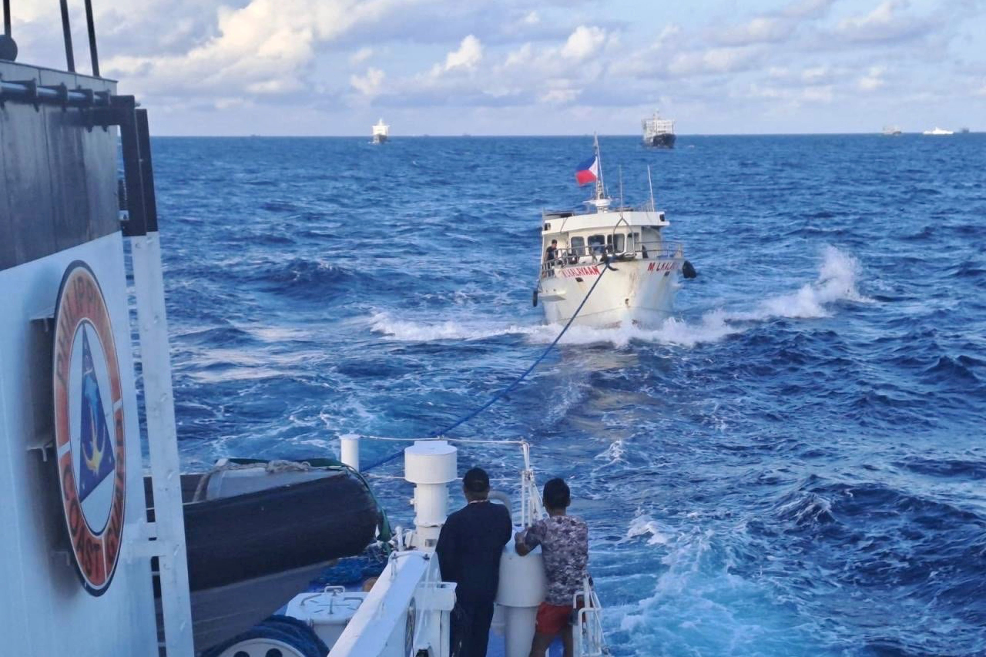 In this handout photo provided by the Philippine Coast Guard, Philippine Coast Guard ship BRP Sindangan, left, tows Philippine navy-operated supply boat M/L Kalayaan after it’s engines were damaged due to water cannons from Chinese Coast Guard as it approached Second Thomas Shoal, locally known as Ayungin Shoal, in the disputed South China Sea on Sunday 10 December 2023