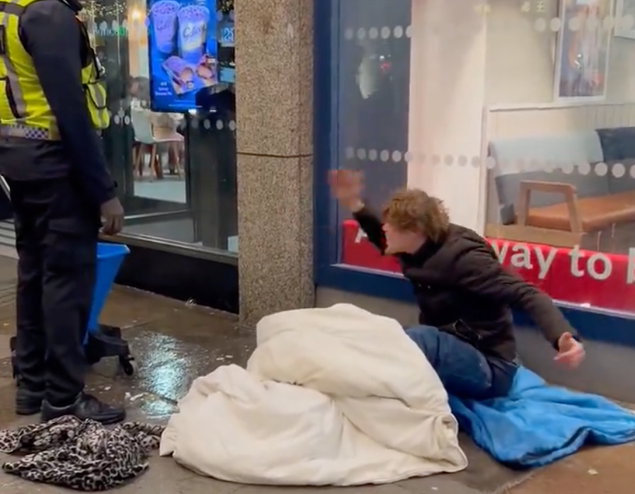 The security guard could be seen splashing more water onto the ground directly next to the man’s possessions