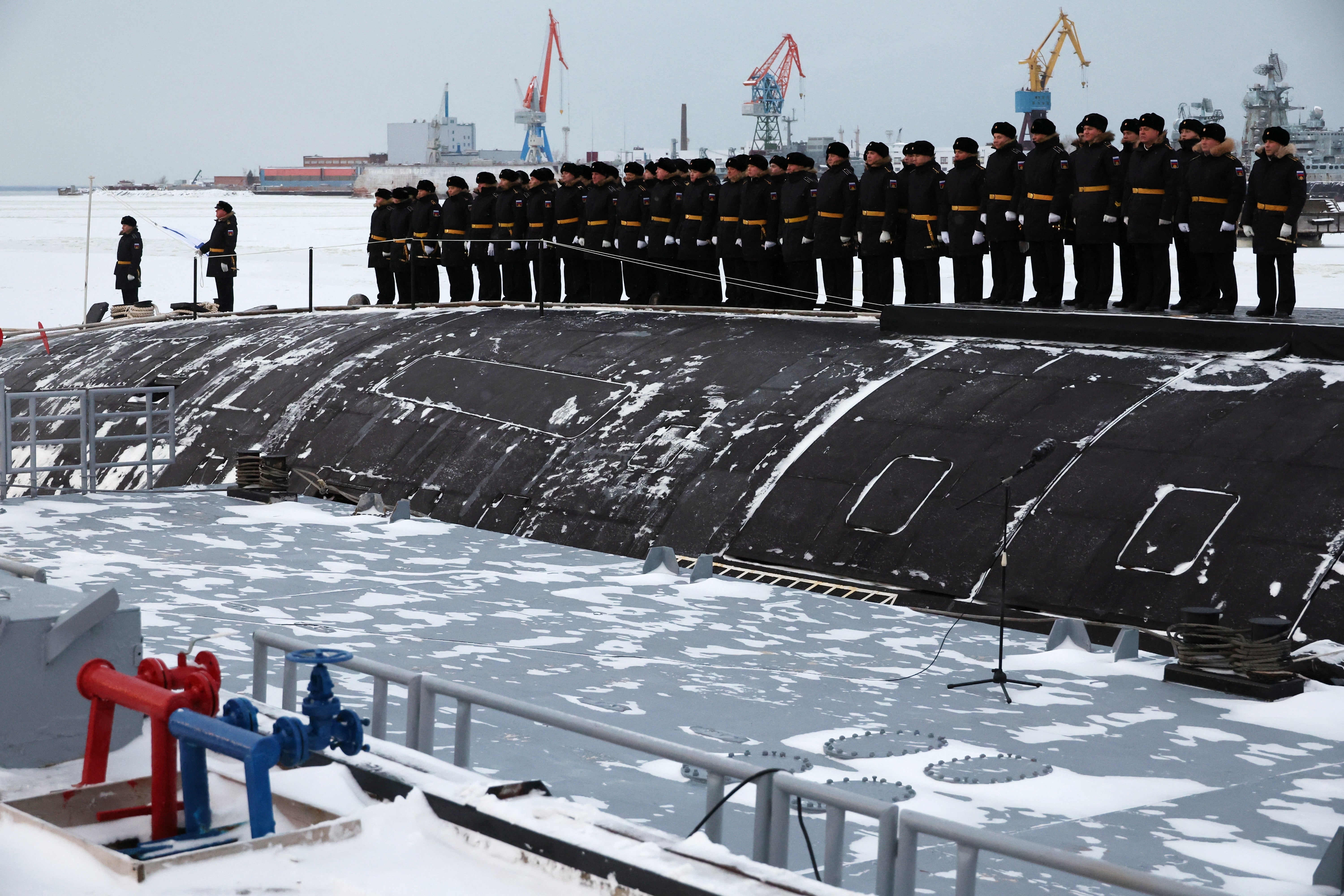 Sailors attend a flag-raising ceremony on the nuclear-powered submarine Krasnoyarsk at the naval base in the northern city of Severodvinsk, Russia