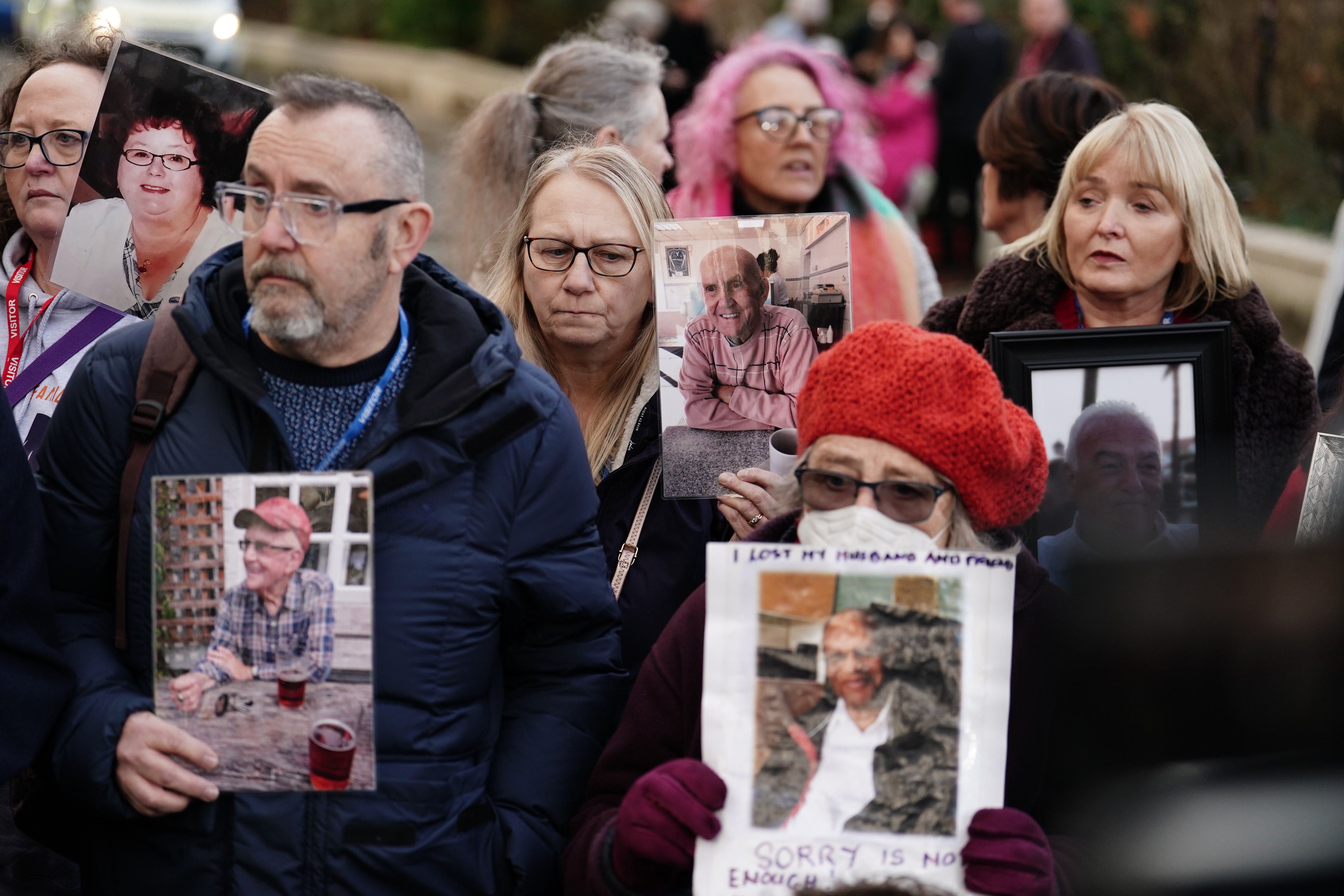 Members of Covid Bereaved Families, holding photographs of their relatives who died during the pandemic, outside Dorland House in London, where Prime Minister Rishi Sunak was giving evidence to the UK Covid-19 Inquiry (Jordan Pettitt/PA)