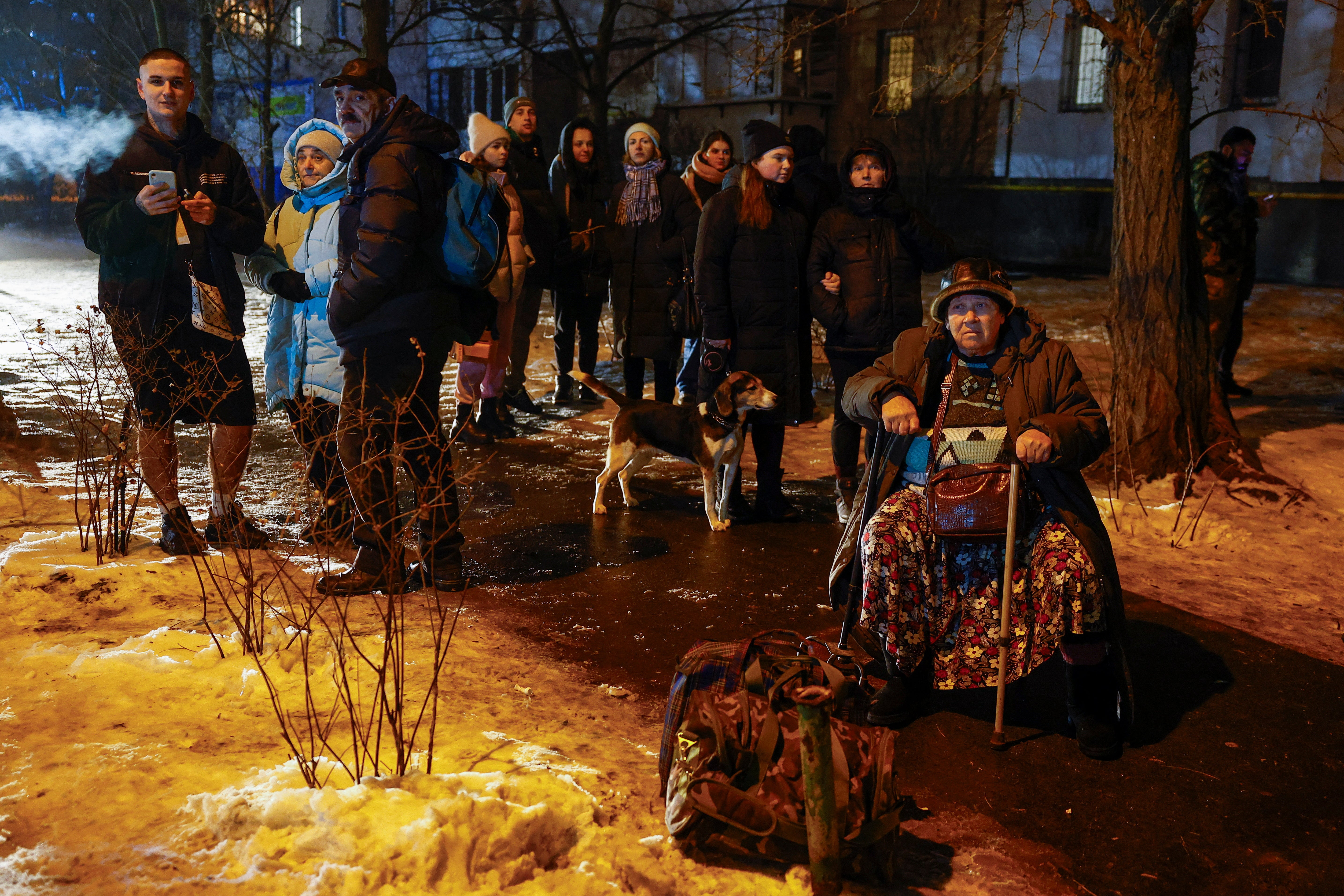 Local residents gather outside of their apartment building damaged during a Russian missile strike, amid Russia’s attack on Ukraine