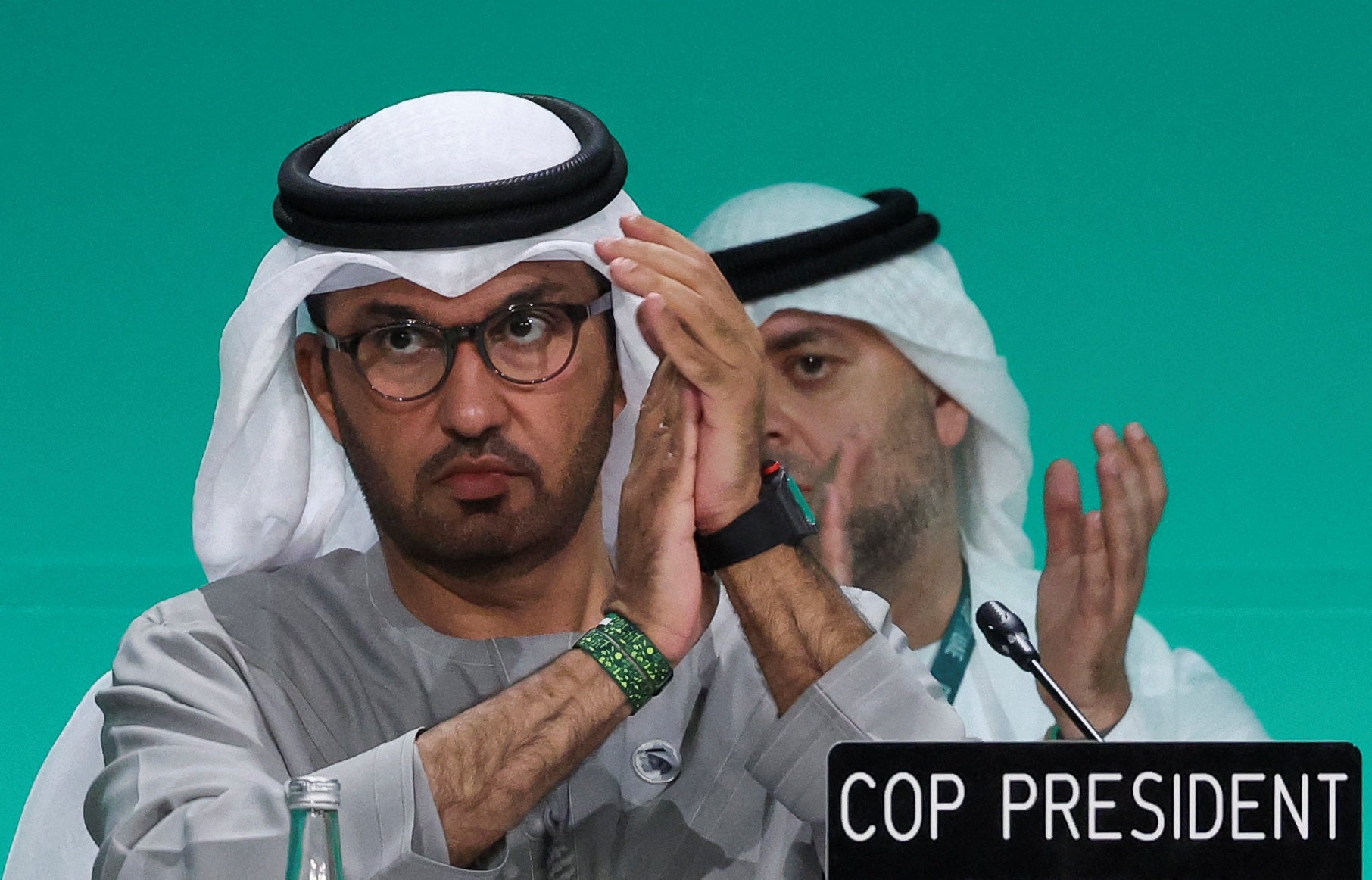 COP28 President Sultan Ahmed Al Jaber applauds as he attends a plenary meeting