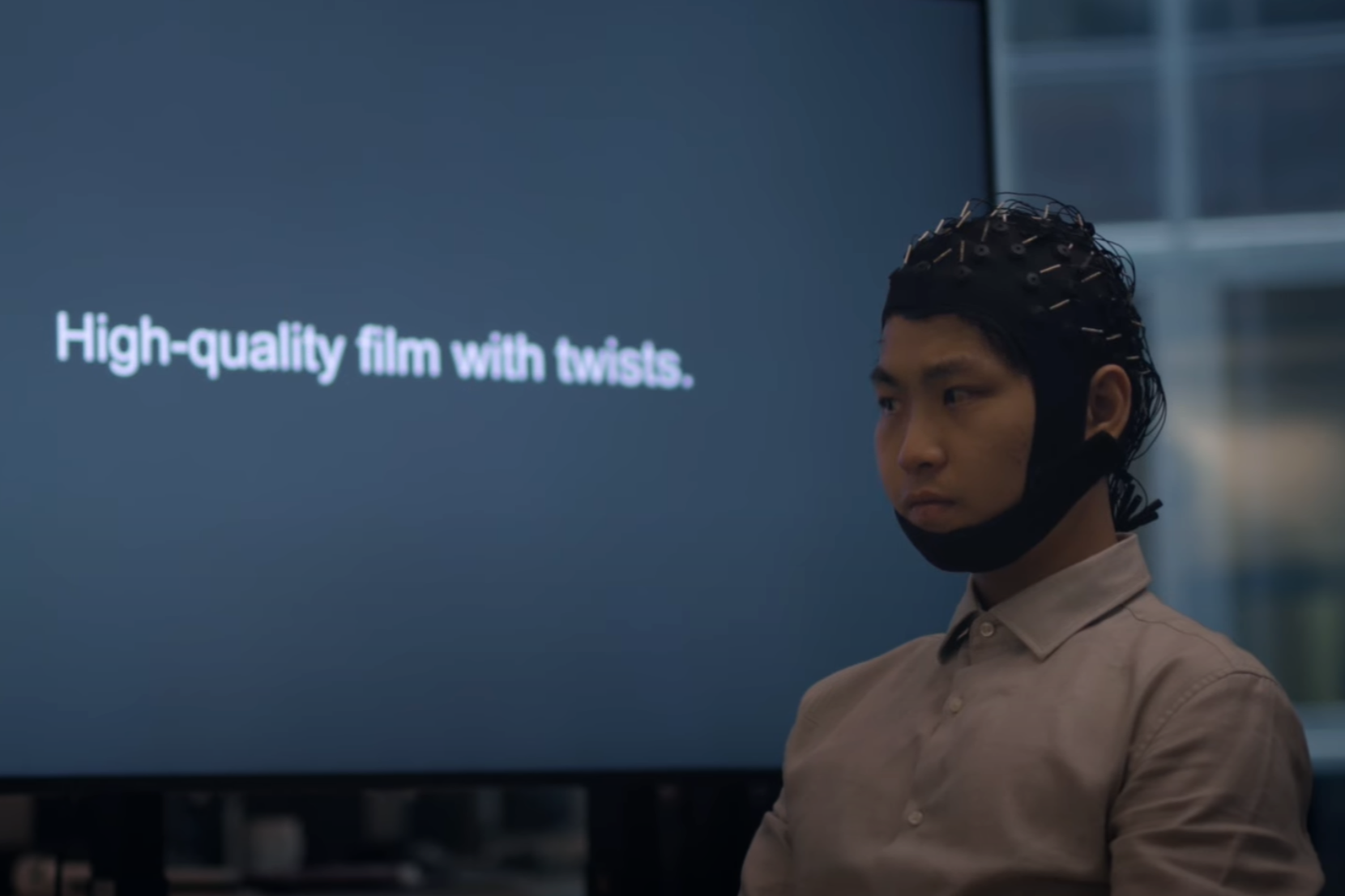 A participant in the mind-reading study wears a cap that records electrical brain activity while they silently read text