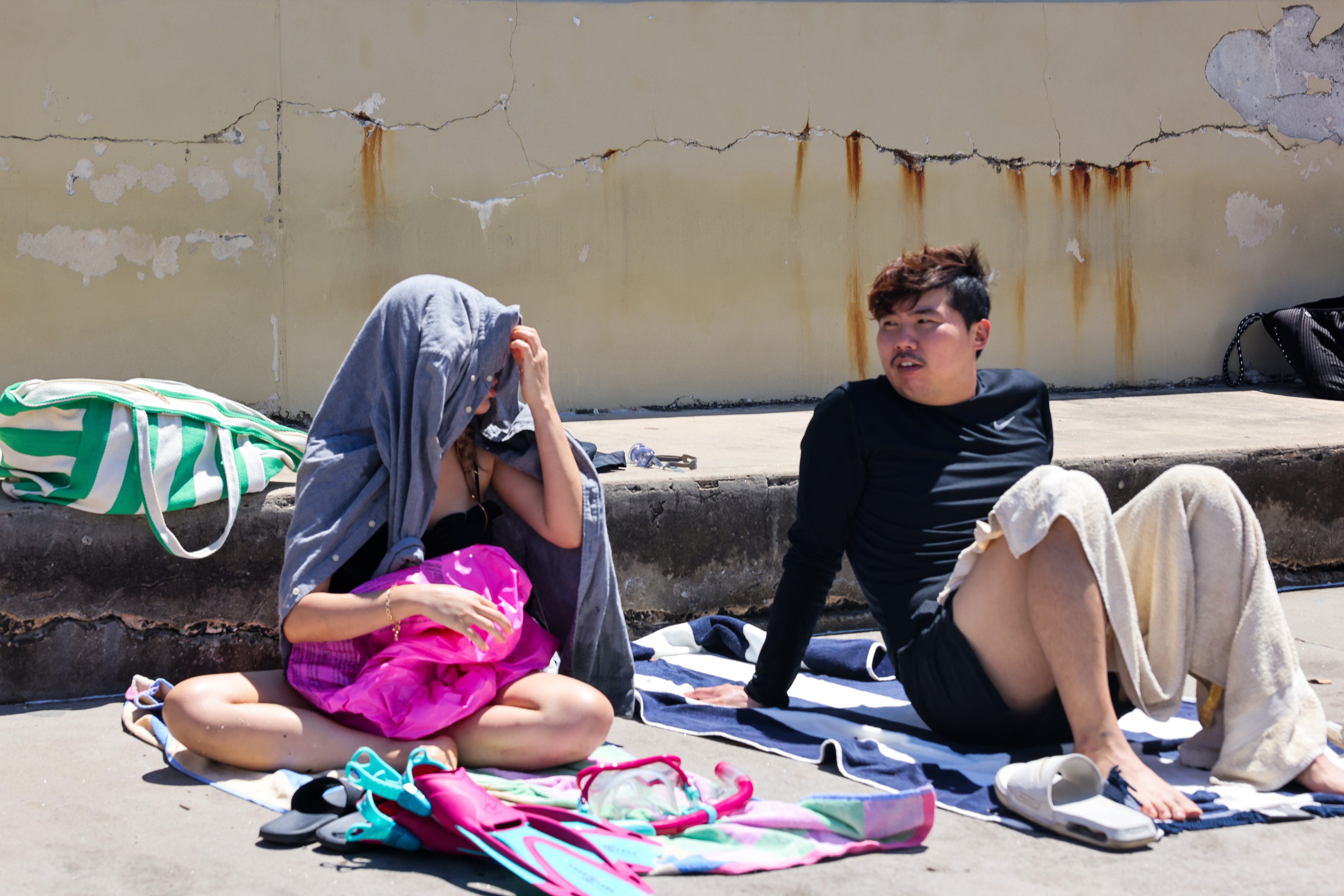 A woman uses a shirt to shelter from the sun at Clovelly Beach in Sydney, Australia