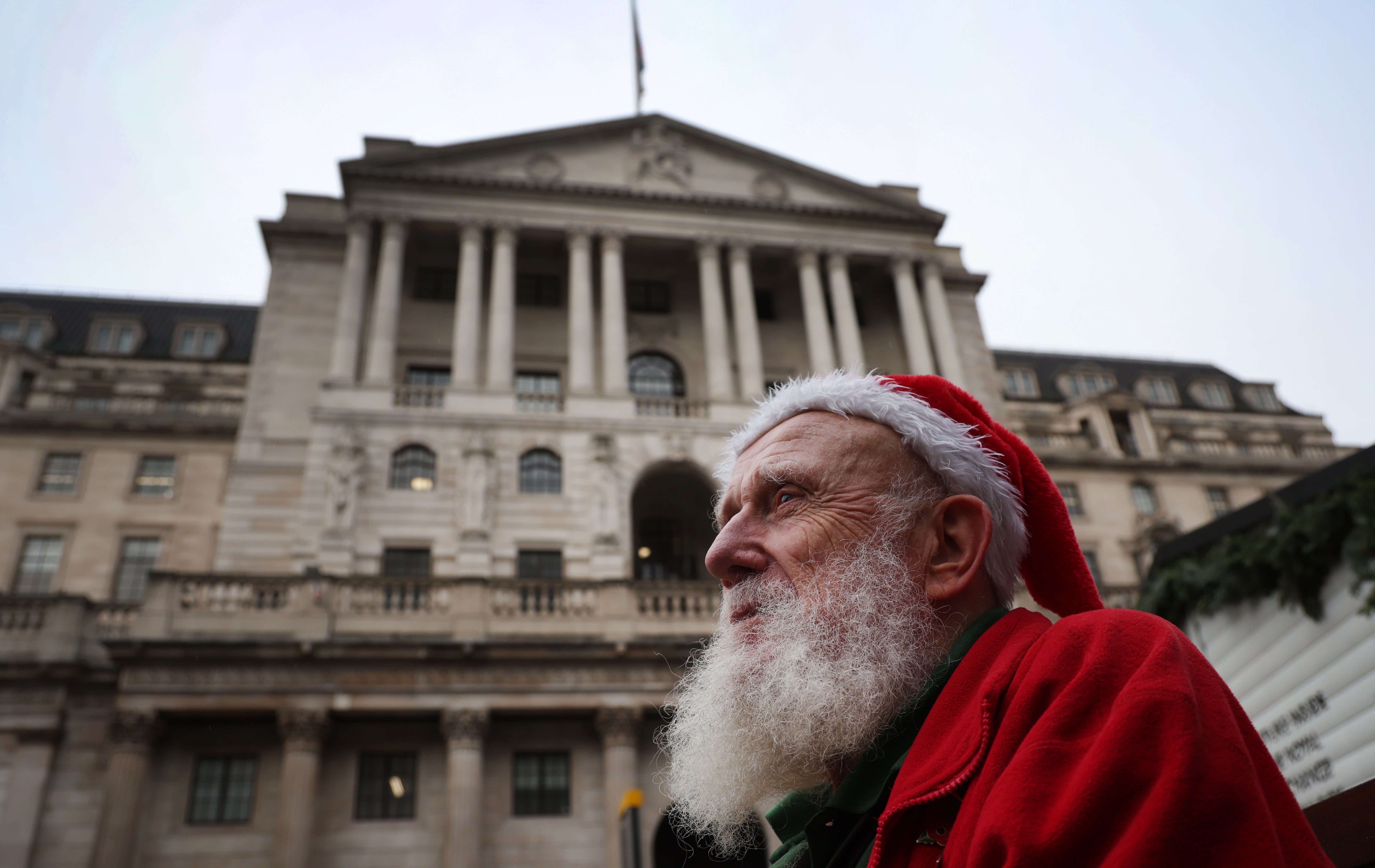 Festively frugal: a man wearing a Santa hat outside the Bank of England as it pegged interest rates on Thursday