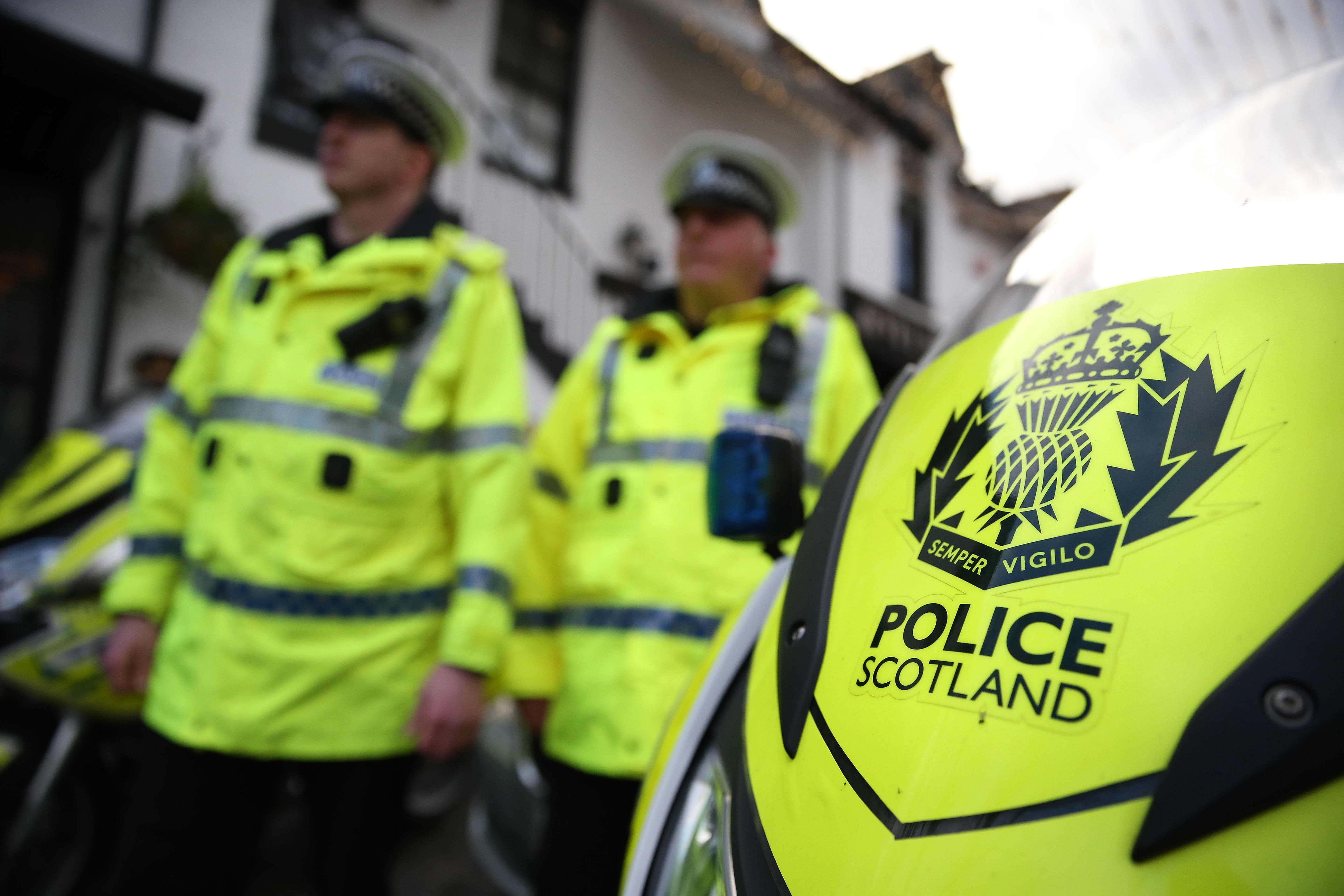 Stock image of Scottish police officers behind a police vehicle (Andrew Milligan/PA)