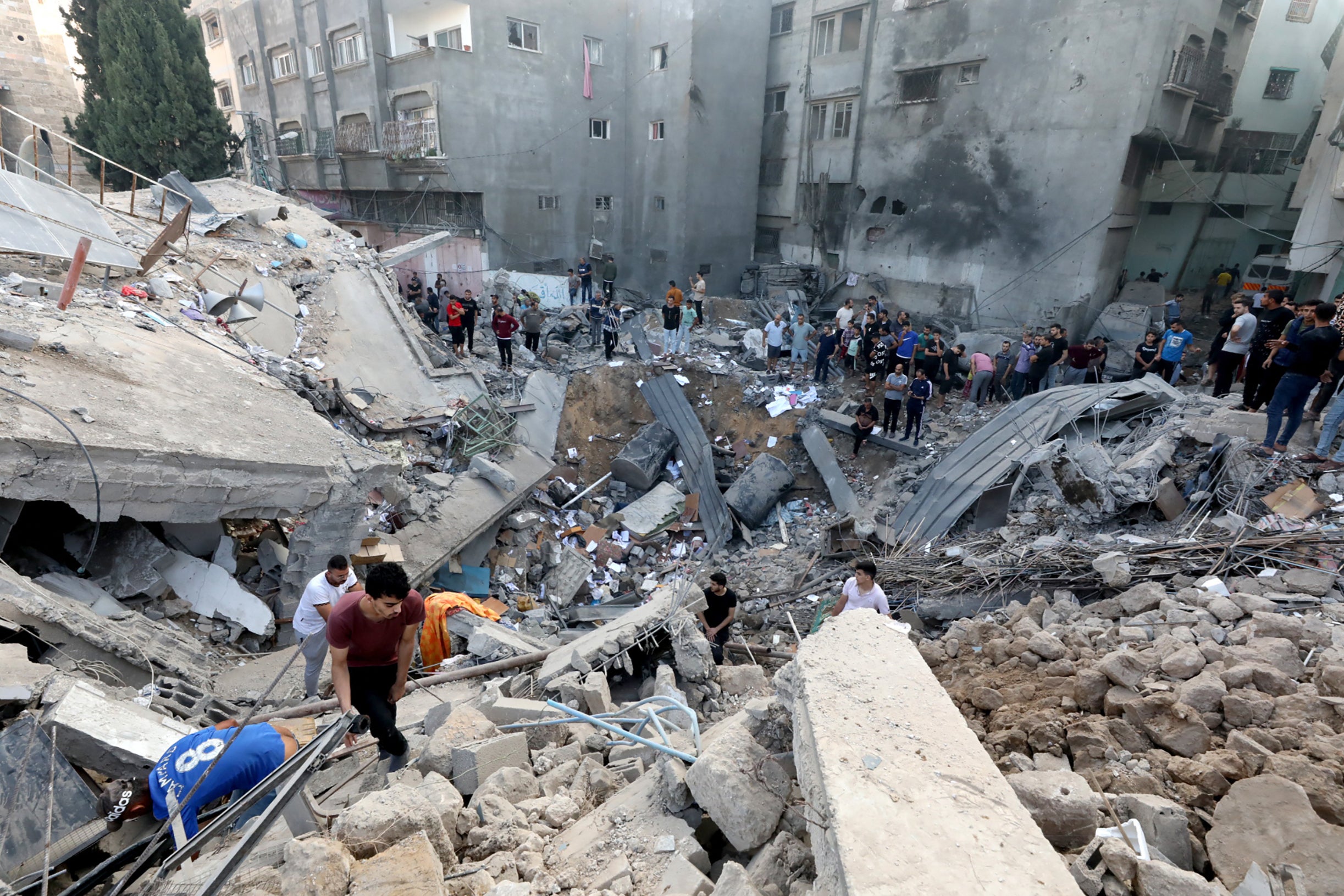 Palestinians search the destroyed annexe of the Greek Orthodox Saint Porphyrius Church after the strike in October