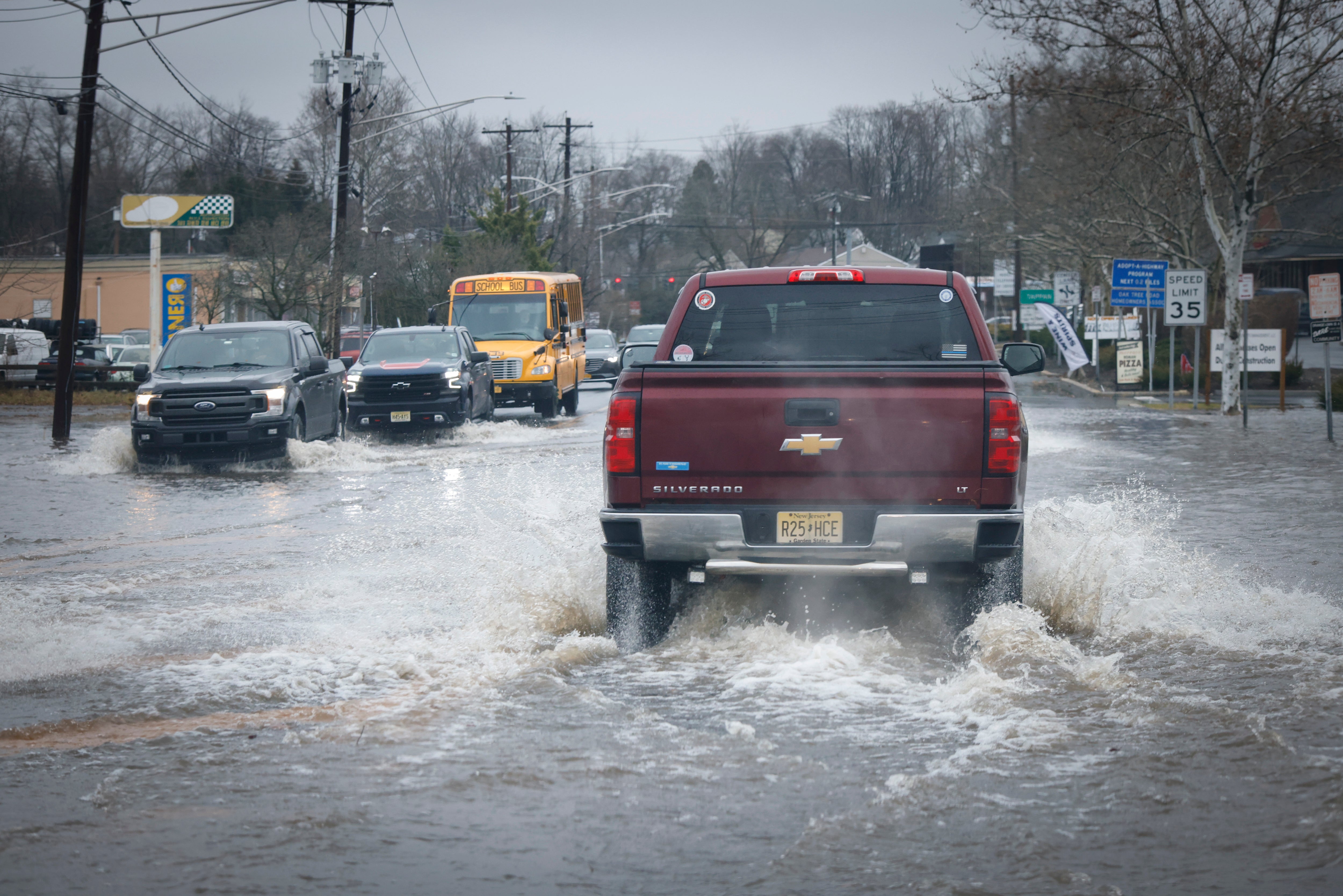 Cars drive through a flooded street in New Jersey after a large rainstorm