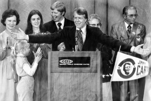 Then-Democratic presidential candidate Jimmy Carter (c), flanked by his wife Rosalynn (L), his daughter Amy (2nd L) and family, reacts during a rally in Atlanta in 1976