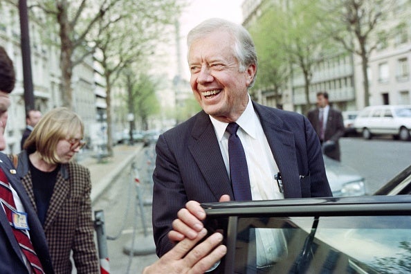 Former president Jimmy Carter smiles as he arrives at Elysee presidential palace on April 4, 1990 to meet Palestine Liberation Organisation leader Yasser Arafat and French president Francois Mitterrand to discuss Mideast peace