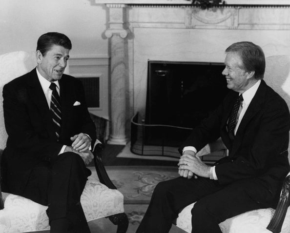 Former president Ronald Reagan (left) talking to former president Jimmy Carter at a meeting regarding the AWACS sale of planes to Saudi Arabia, in the Oval Office of the White House, Washington, DC on October 13, 1981