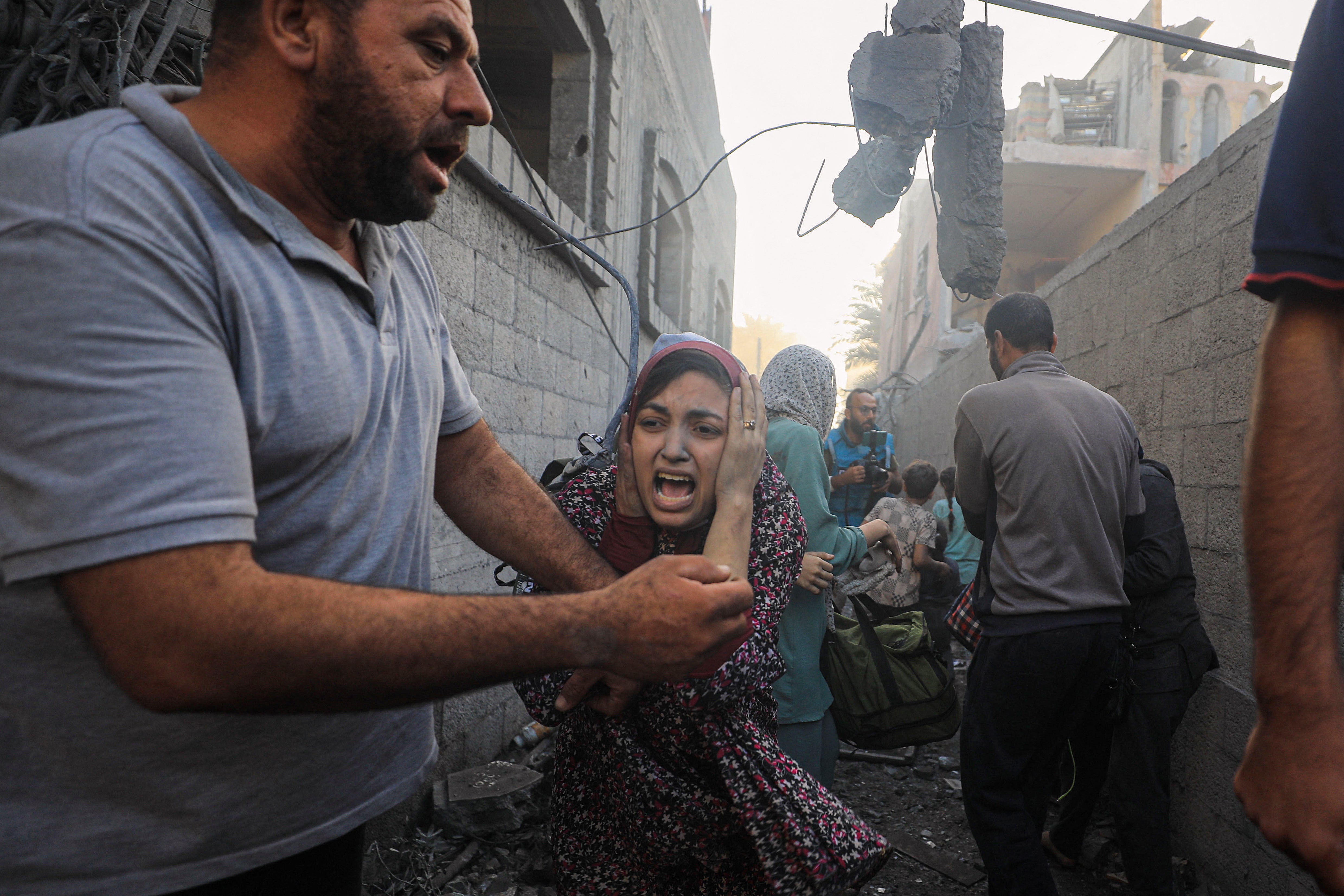 People flee following Israeli air strikes on a neighbourhood in the al-Maghazi refugee camp in the central Gaza Strip on 6 November