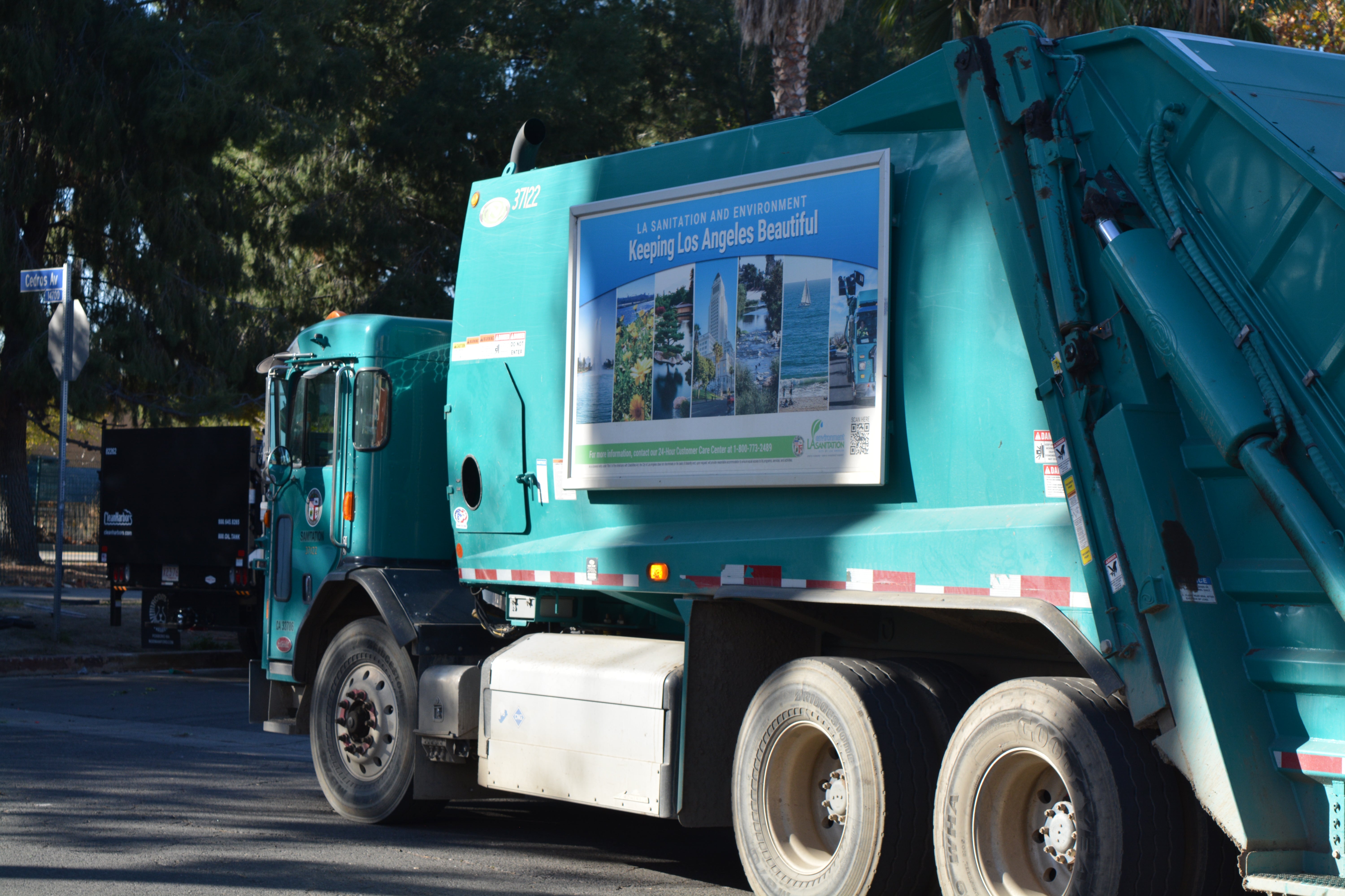 A sanitation department garbage truck idles near the Aetna Street homeless encampment on 14 December, 2023