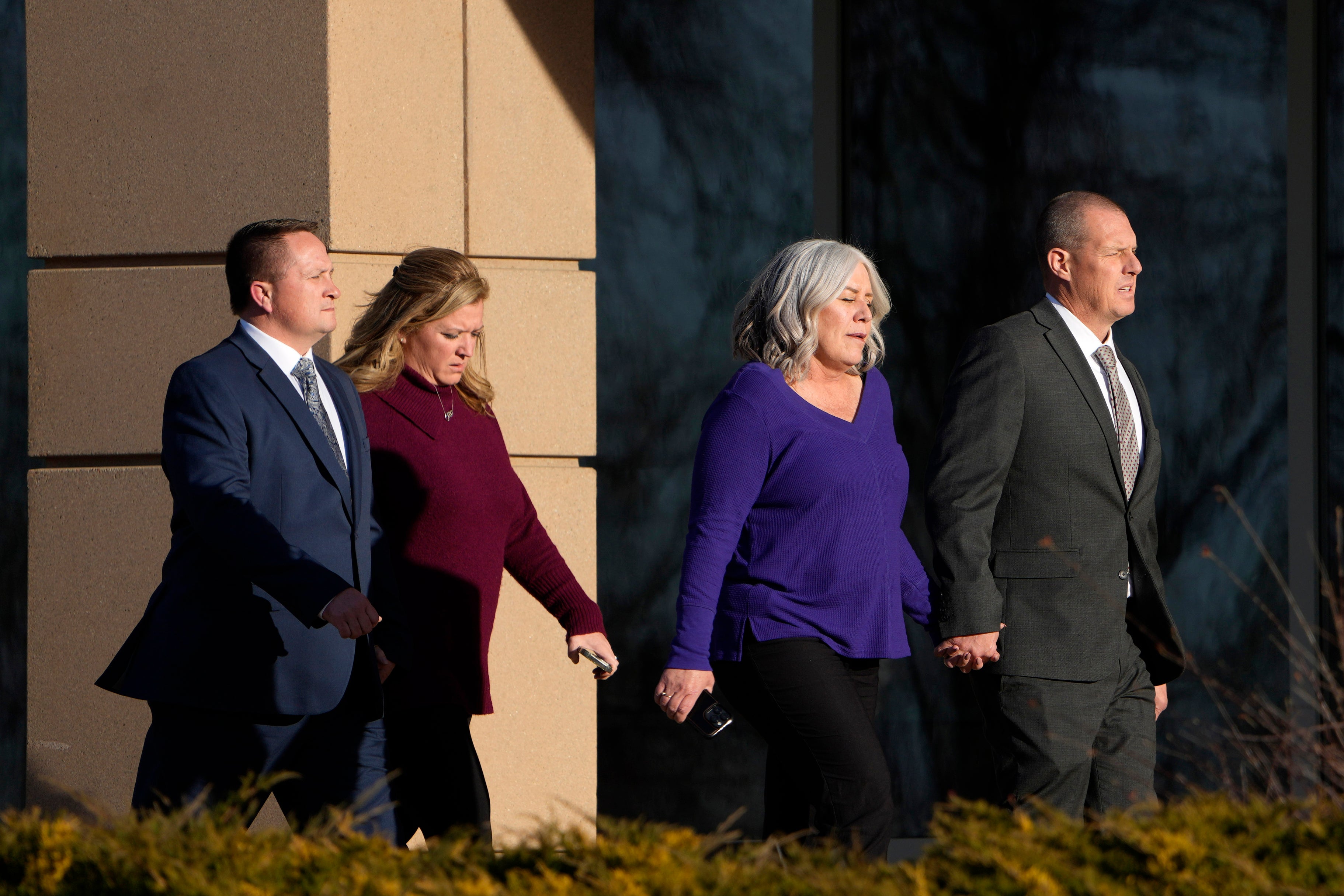 Paramedics Jeremy Cooper, far left, and Peter Cichuniec, far right, enter the Adams County, Colo., Justice Center, Friday 22 December