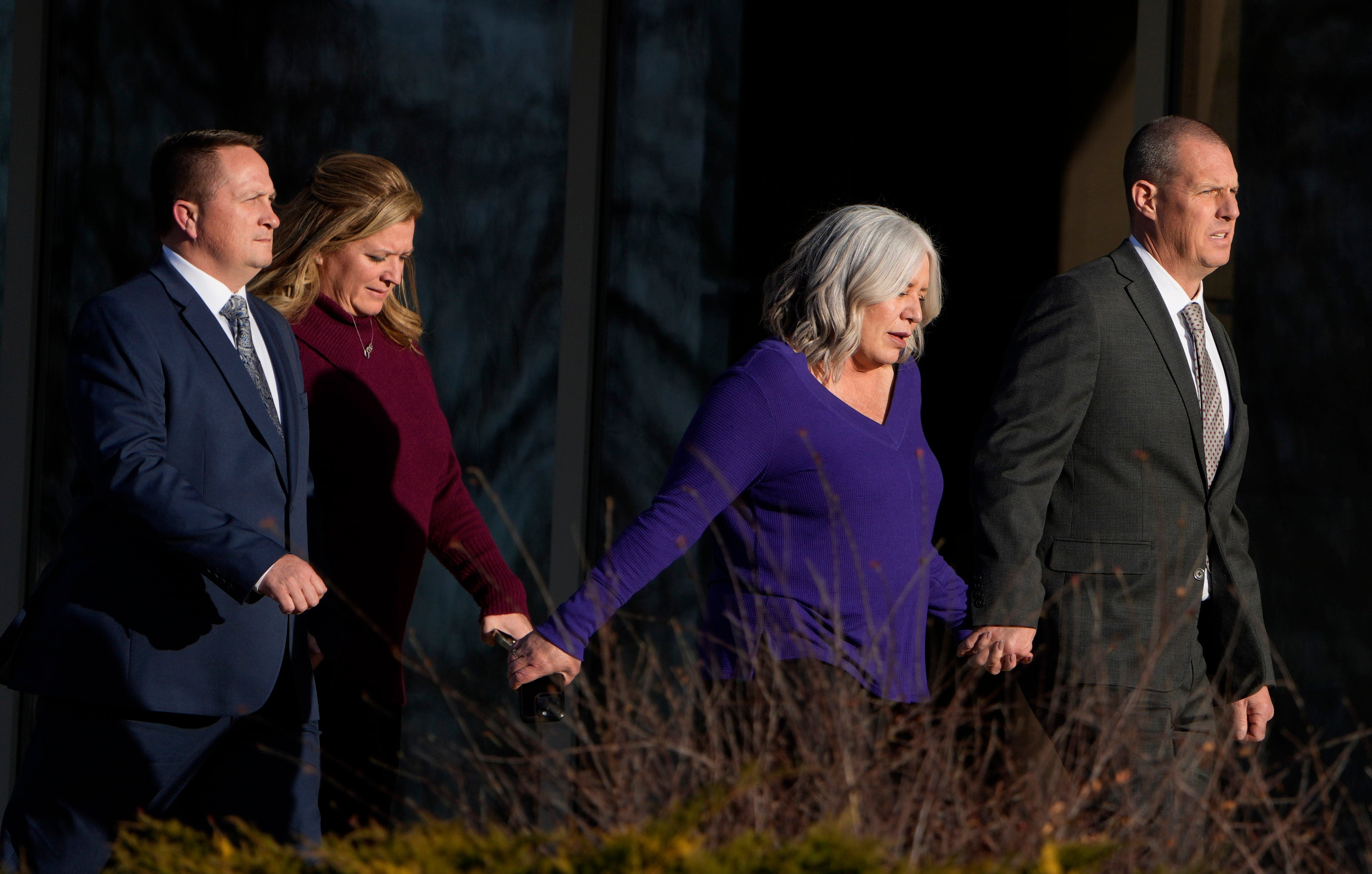 Paramedics Jeremy Cooper, far left, and Peter Cichuniec, far right, enter the Adams County Justice Center, Friday, 22 December in Brighton, Colorado