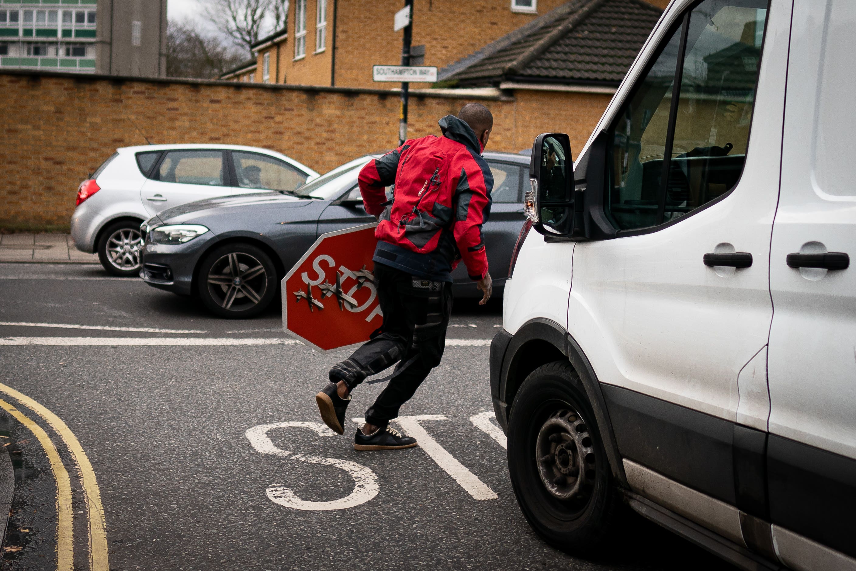 A person removes a piece of art work by Banksy (Aaron Chown/PA)