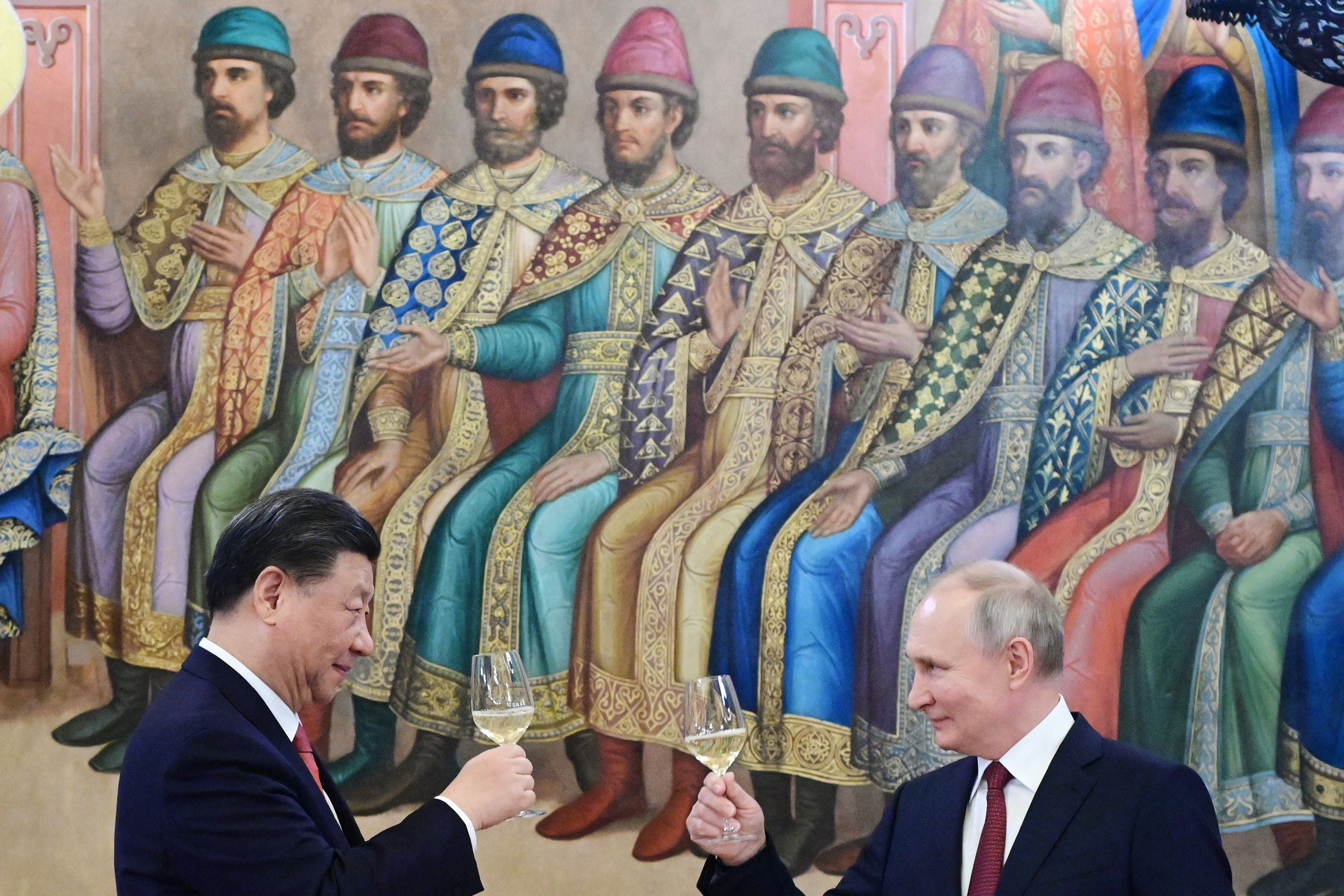 Russian President Vladimir Putin and China's President Xi Jinping make a toast during a reception following their talks at the Kremlin