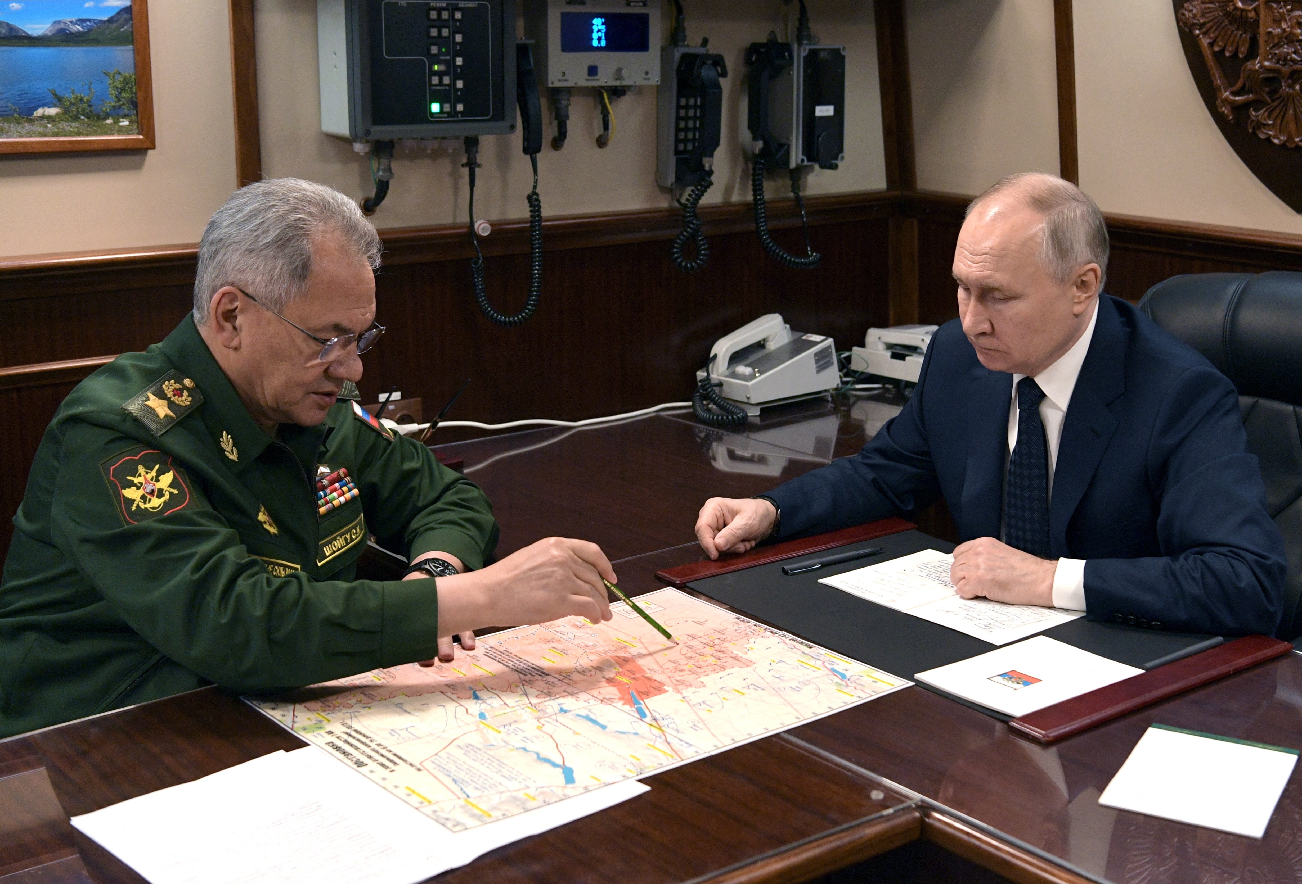 Russia’s President Vladimir Putin listens to Defence Minister Sergei Shoigu during a meeting after a flag-raising ceremony for the Admiral Golovko frigate joining the Russian Navy Fleet at a shipyard in Saint Petersburg,