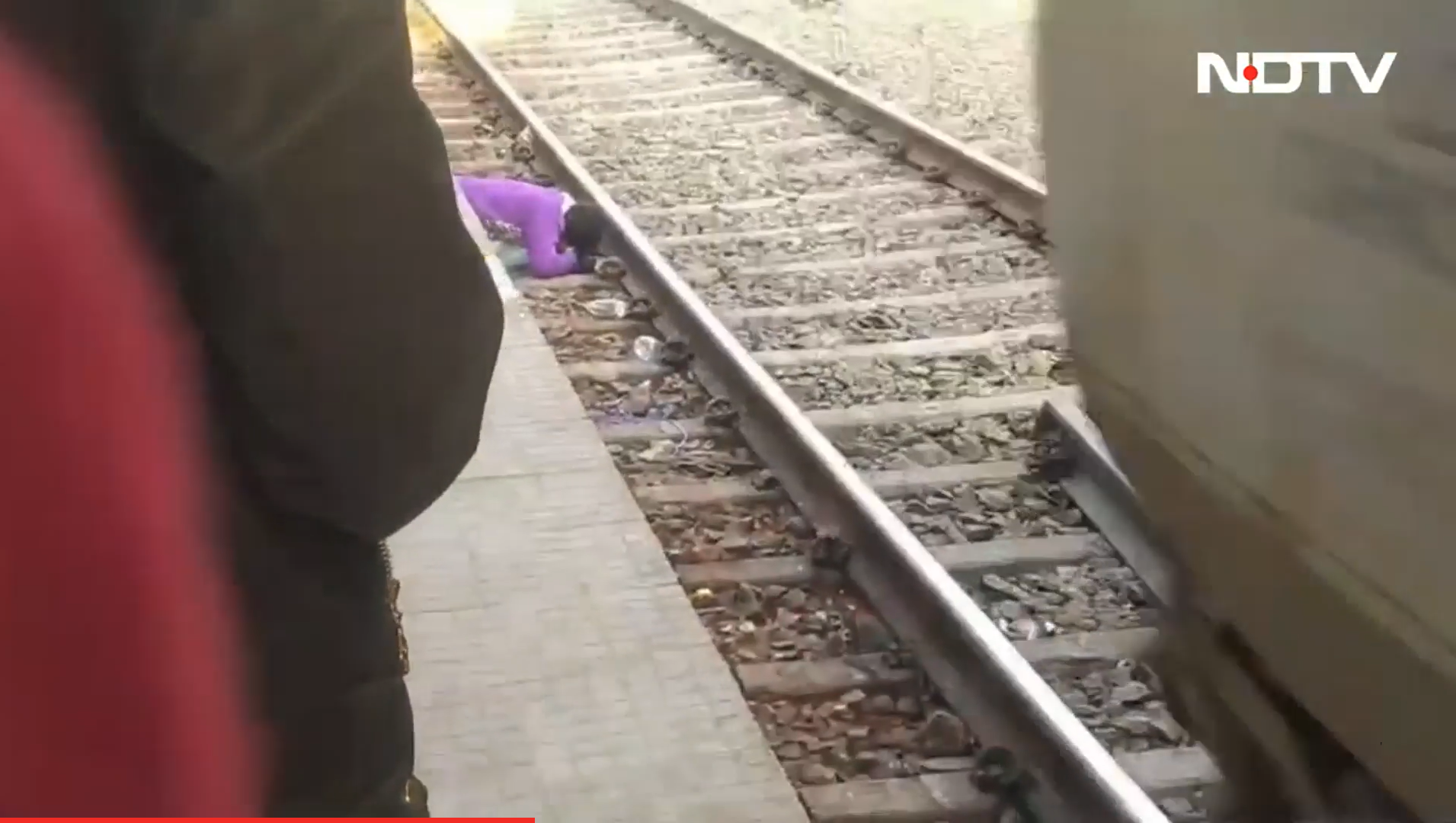 A woman in India sheilds her children from the train