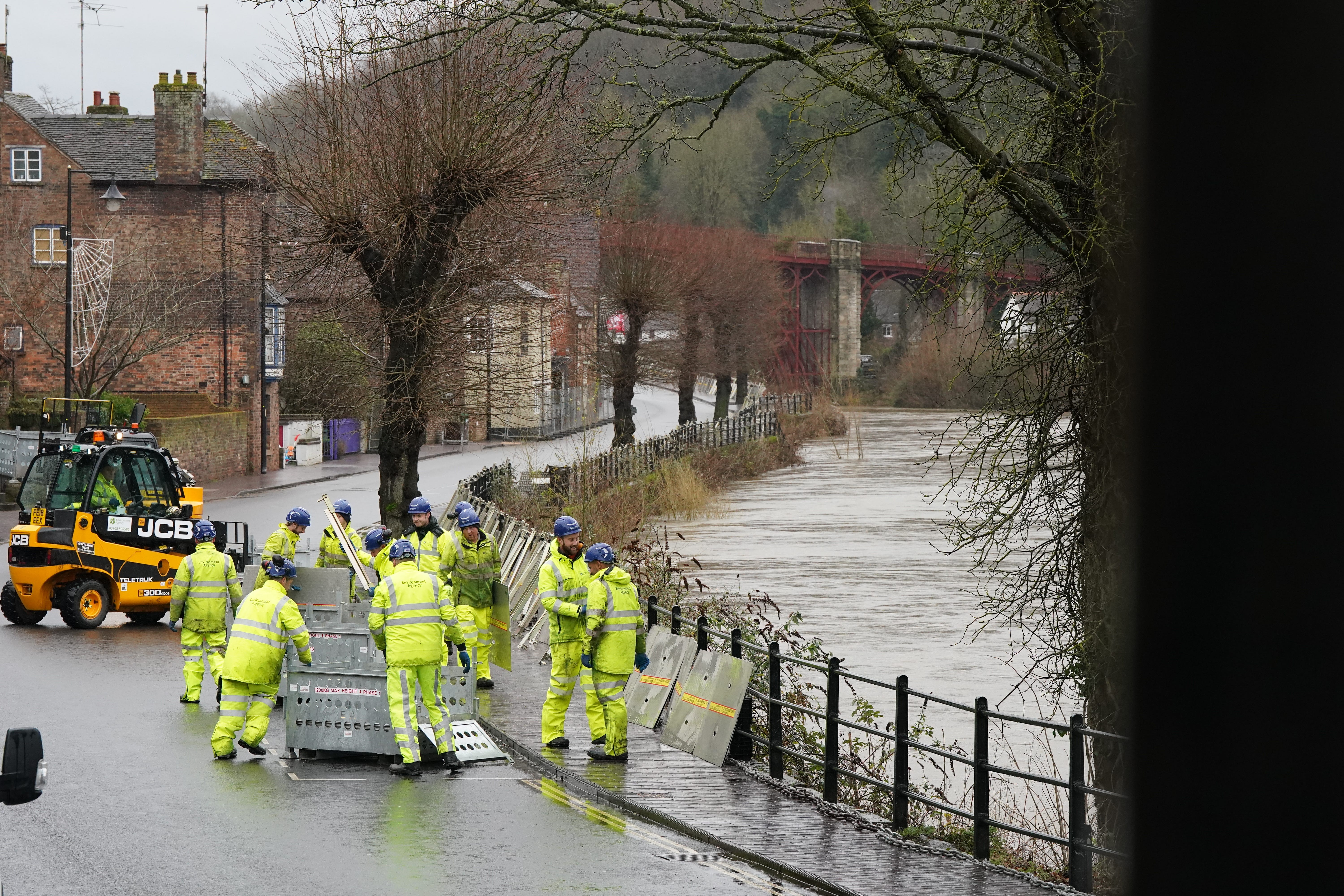 The swollen River Severn as flood defences are put in place along the wharfage at Ironbridge in Telford (Nick Potts/PA)