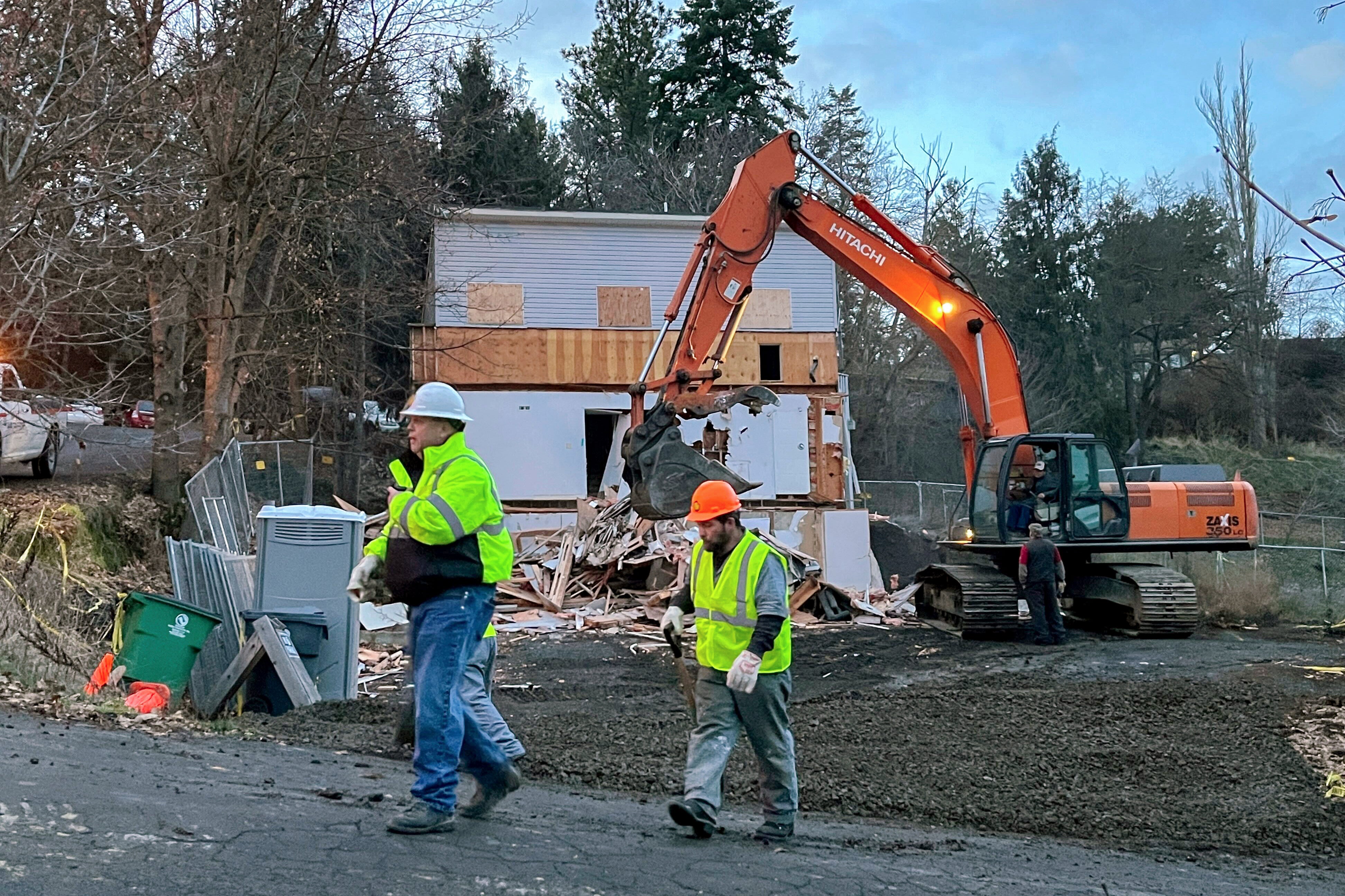 Workers walk past the demolition of the home in Moscow, Idaho, where the four University of Idaho were killed