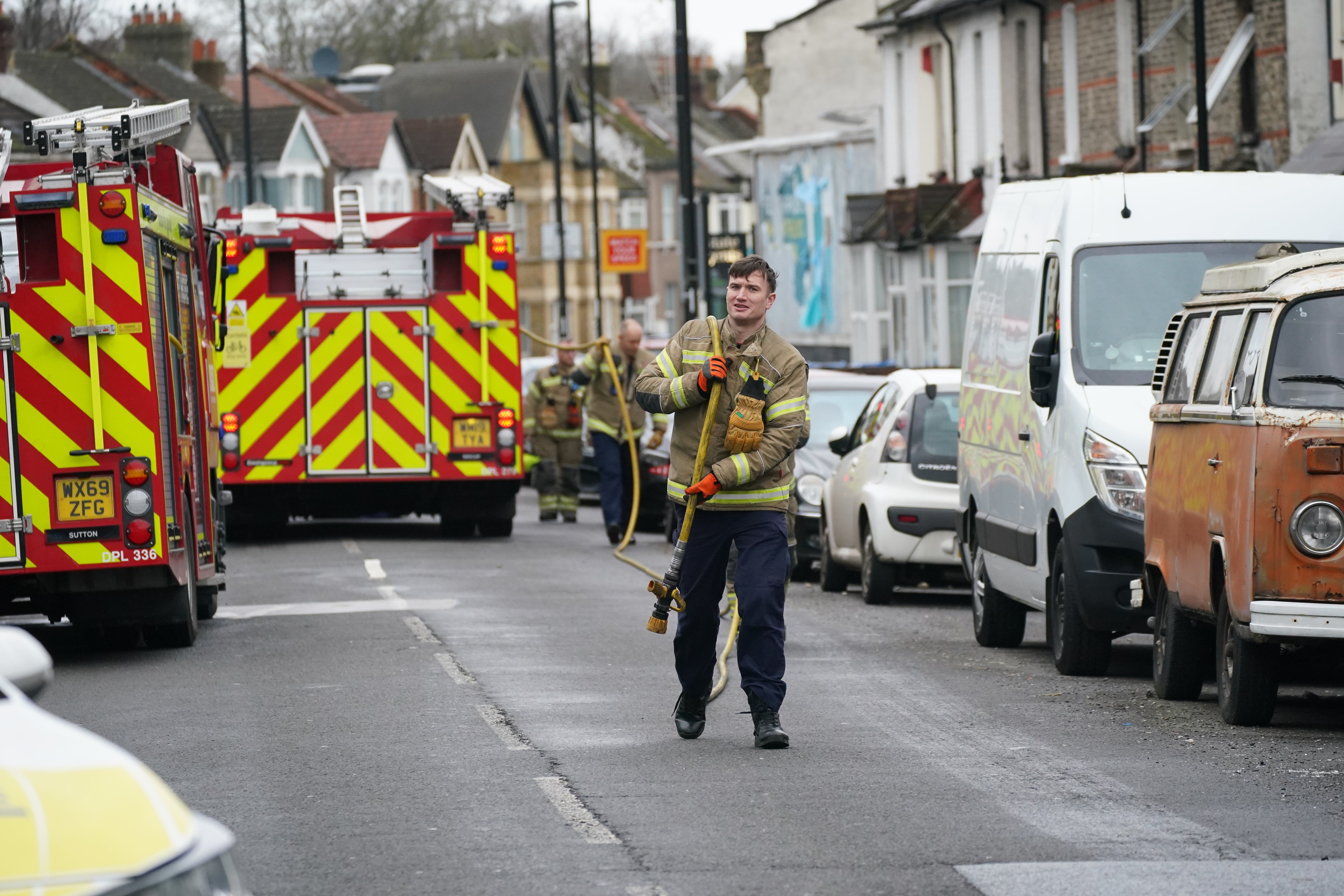 Firefighters clear up equipment outside a property on Sanderstead Road