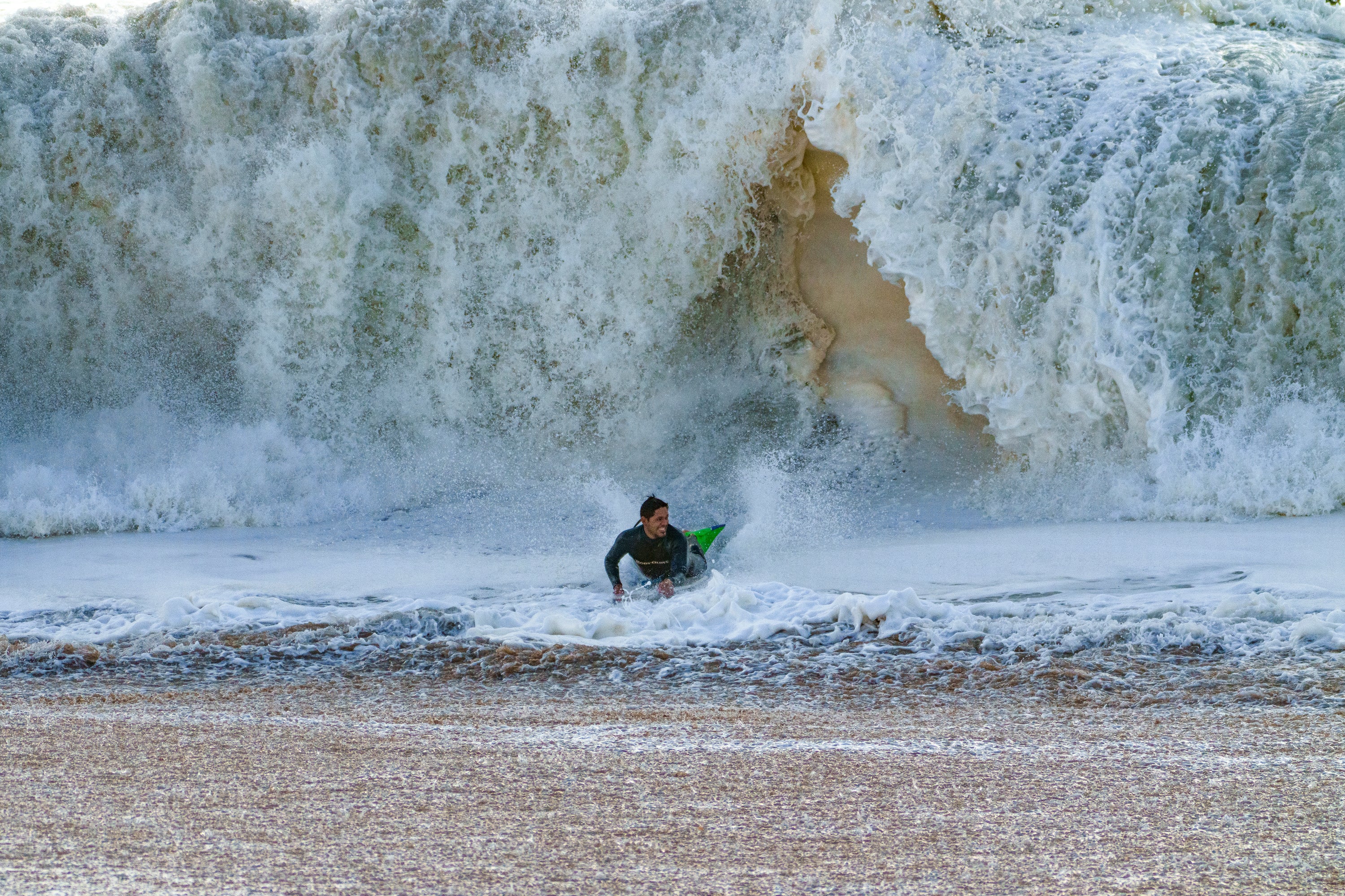 A surfer emerges under the waves in Seal Beach, Calif., Saturday 30 December