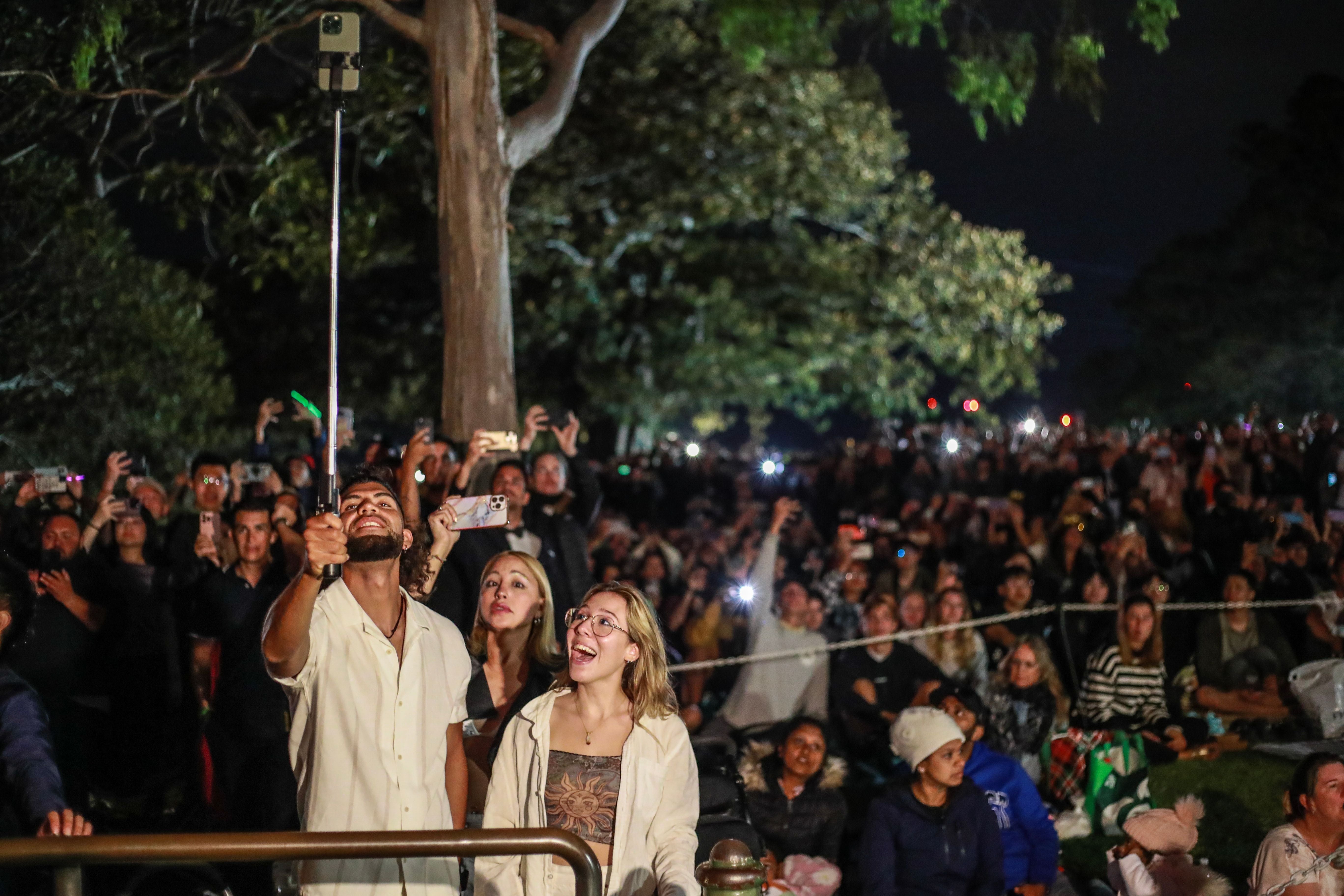 Crowds gather at Mrs Macquarie's Chair to watch the fireworks during New Year's Eve celebrations