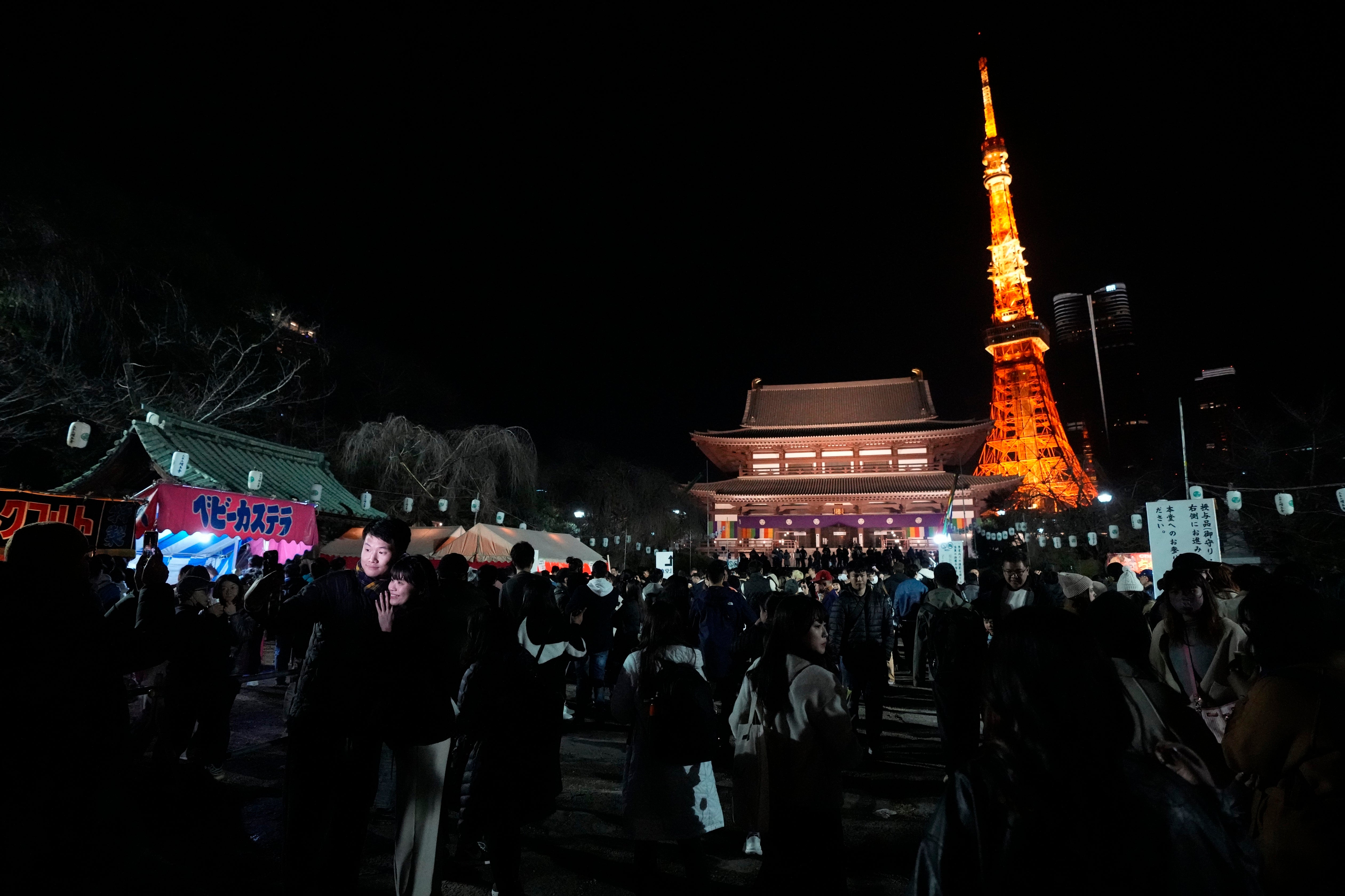 People queue to pray at Zojoji Buddhist temple in Tokyo on New Year’s Eve