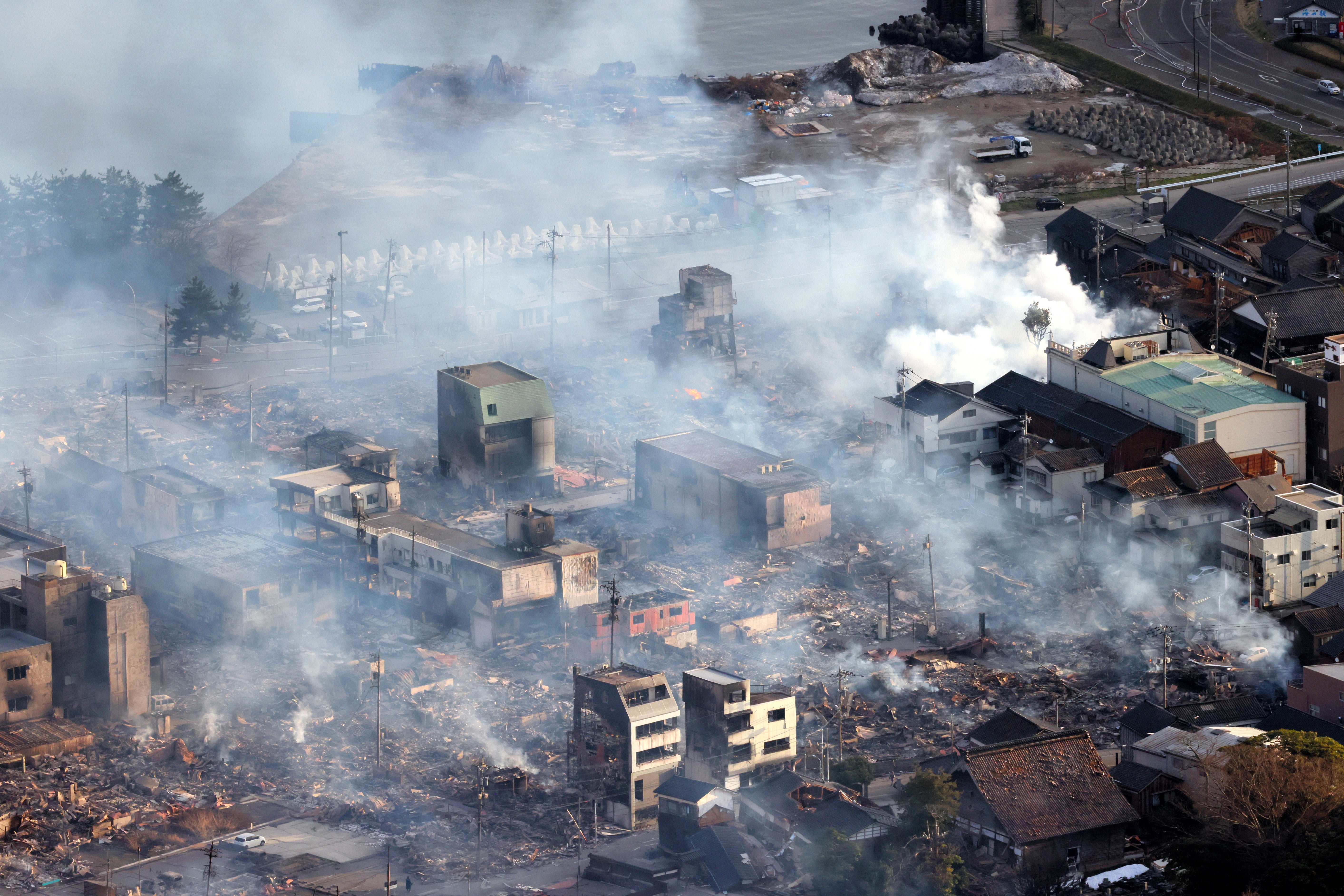 Smoke rise as fire continues after multiple strong earthquakes hit the area on 2 January