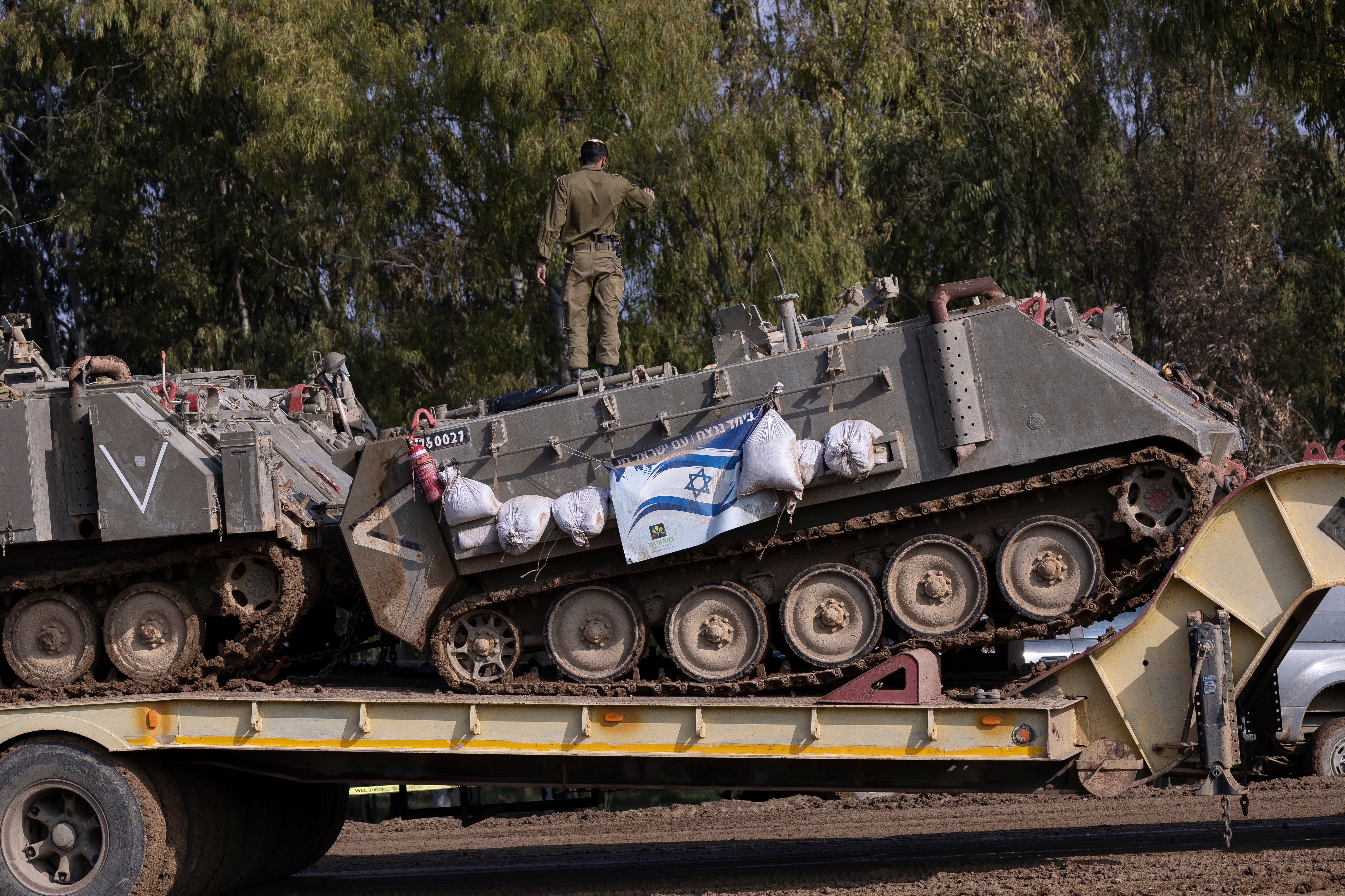 Israeli soldiers load a tank near the border to Gaza