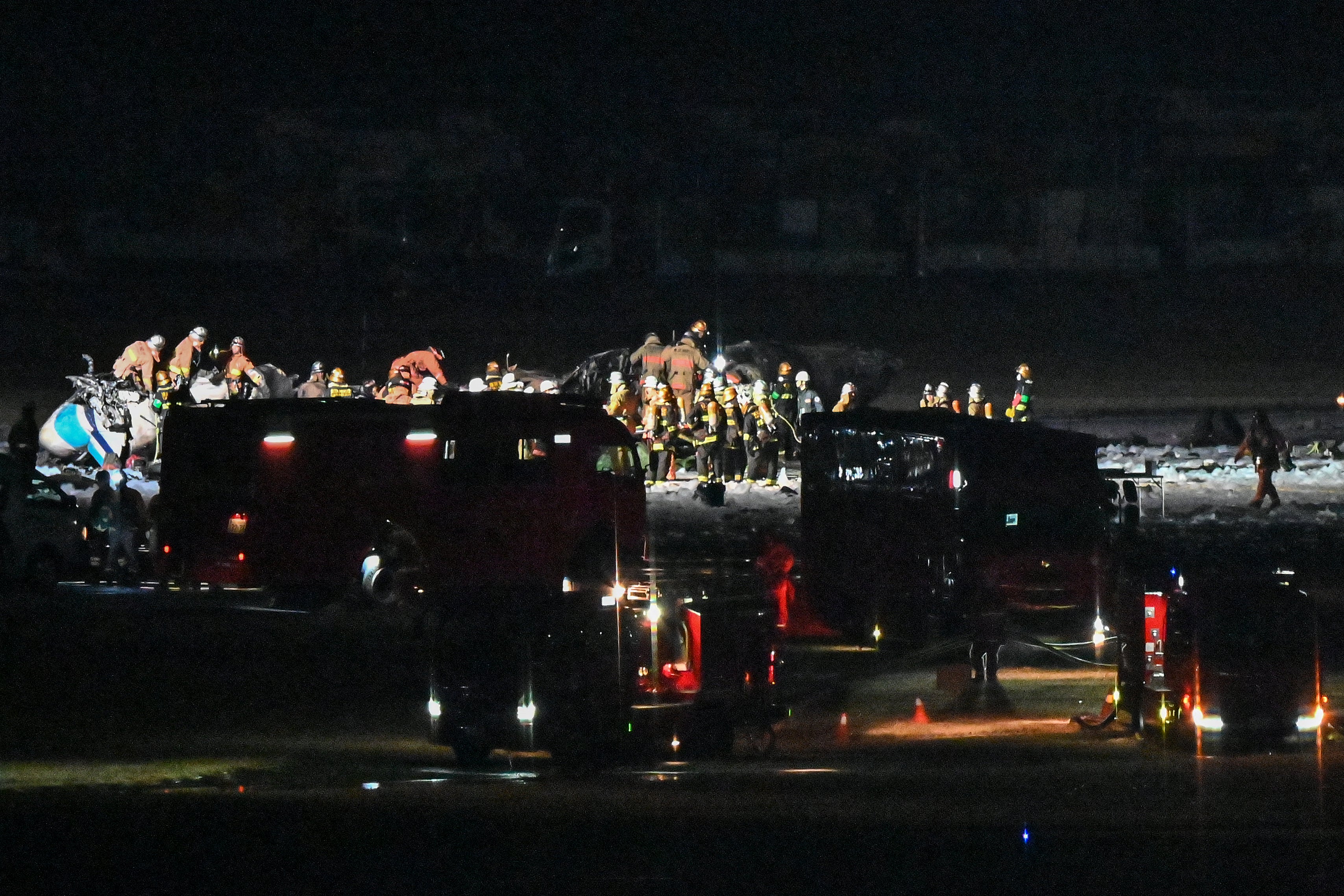 Rescue crews work at the site where a Japan coast guard aircraft collided with a Japan Airlines (JAL) passenger plane on the tarmac at Tokyo International Airport