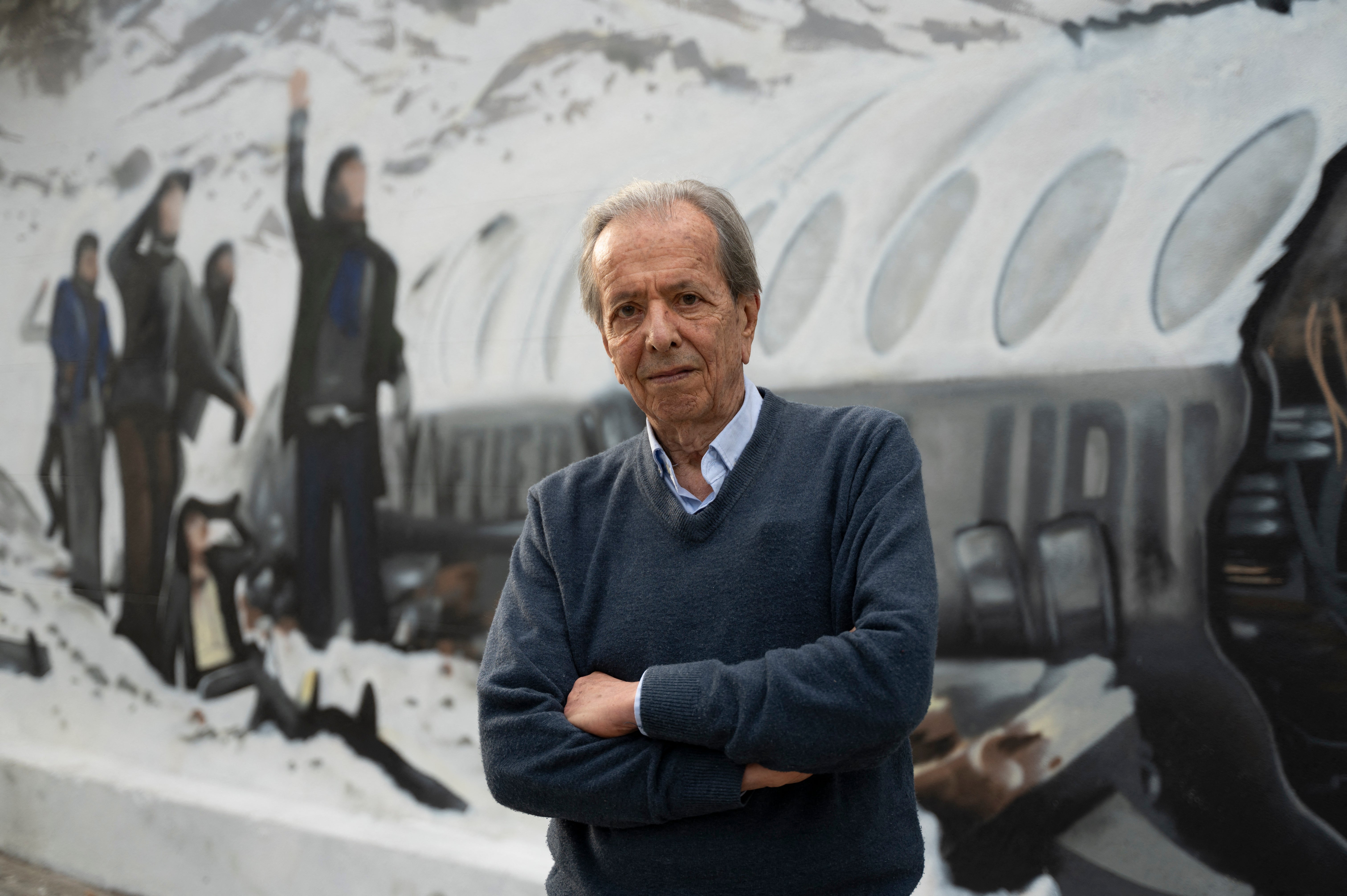 Daniel Fernandez, one of the 16 Uruguayan survivors of the 1972 airplane crash, poses in front of a mural made by Graff Express depicting the accident in Montevideo in November 2023