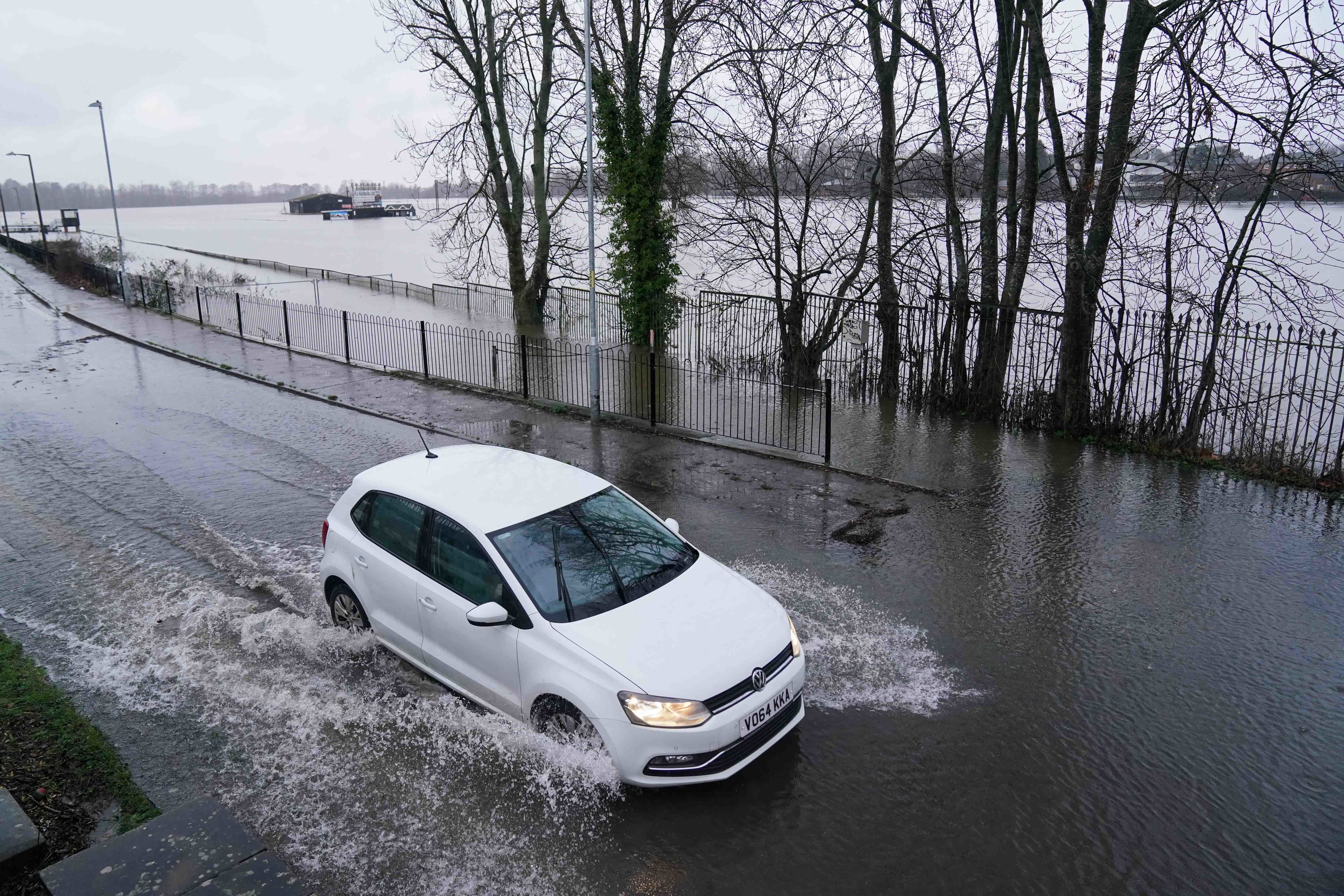 A vehicle drives through standing water close to a flooded Worcester racecourse