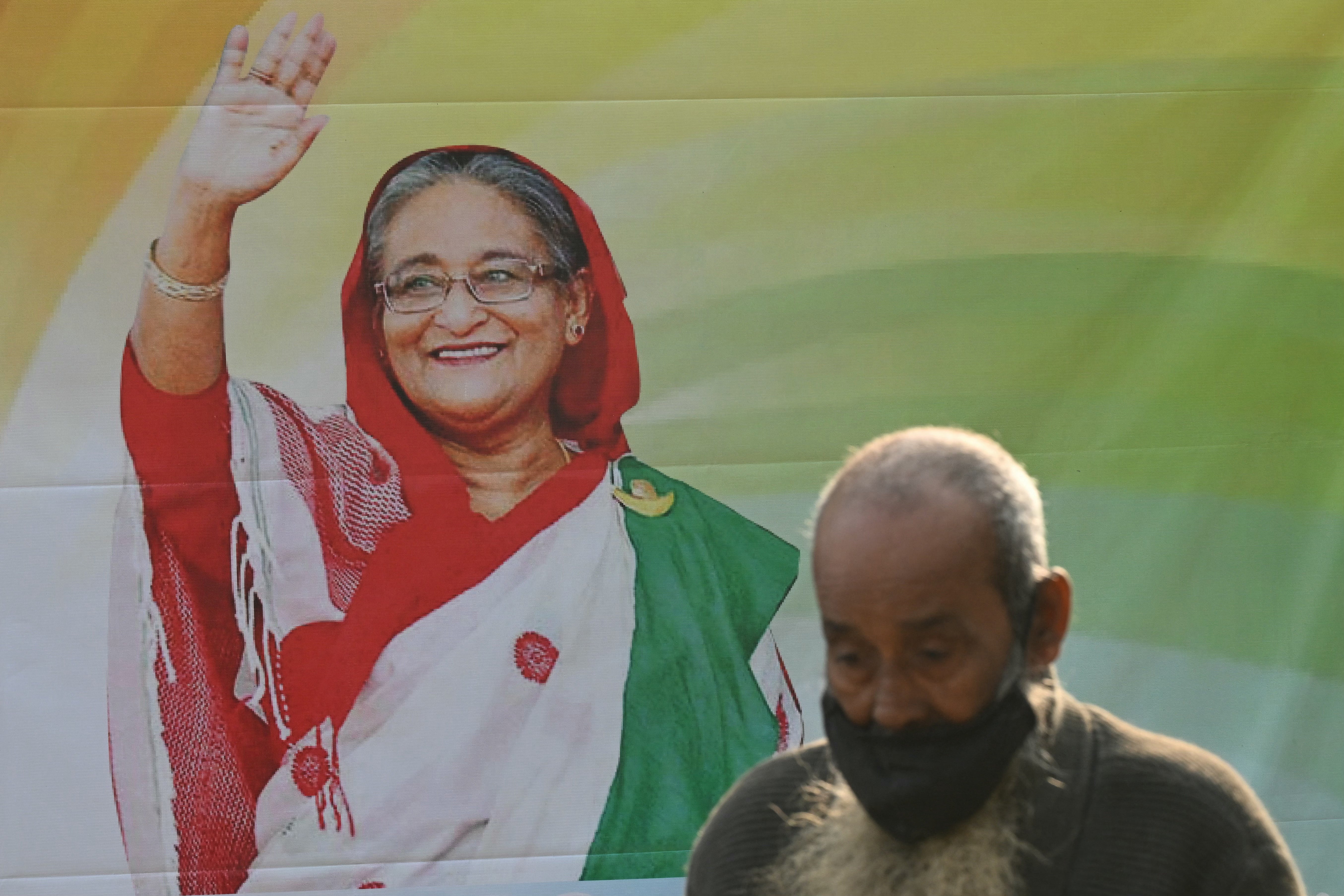 A man walks past a poster of Sheikh Hasina in Dhaka – Bangladesh’s PM is credited with creating domestic stability following a turbulent past