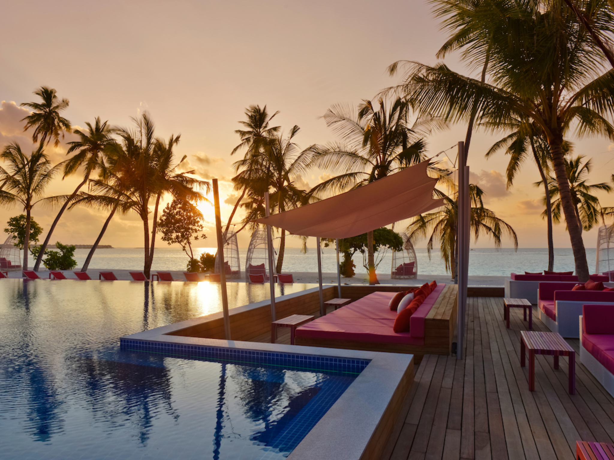 The pink-hued main pool area has its own bar