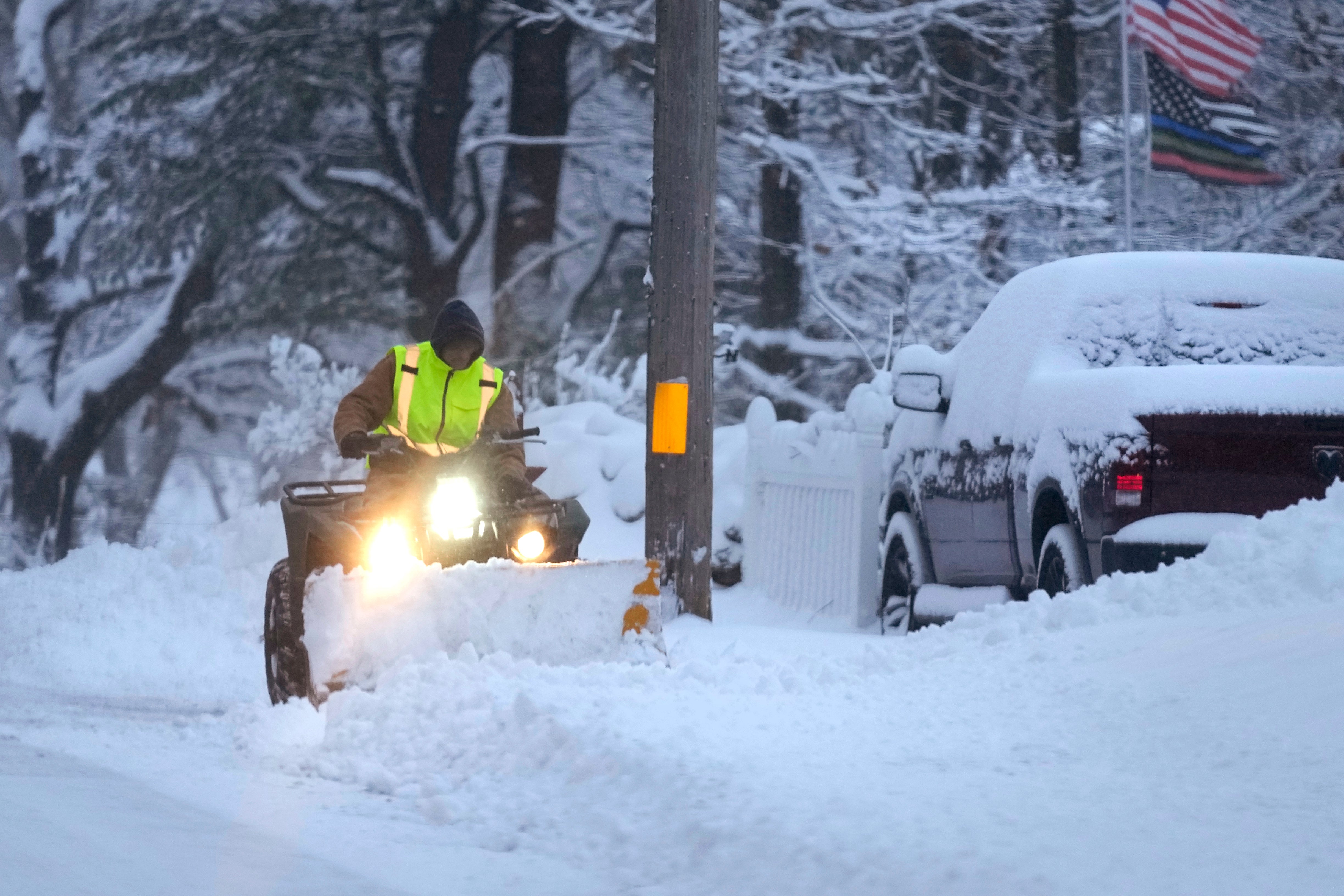 A man plows a snow-covered driveway on 7 January in Derry, New Hampshire